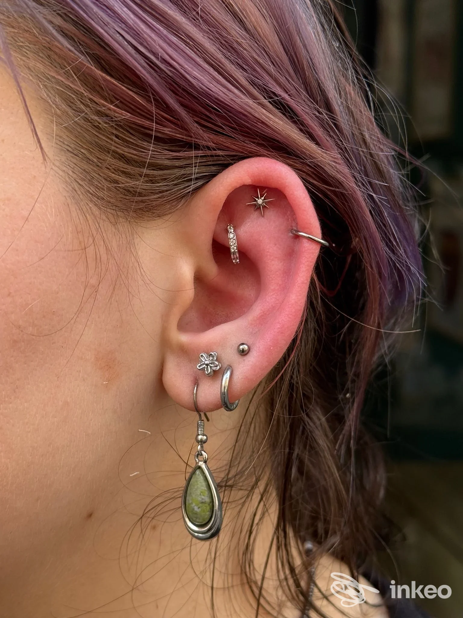 Dettaglio di un orecchio con multipli piercing e gioielli, scatto per portfolio realizzato da HAPAX - Tattoo & Piercing a Torino.