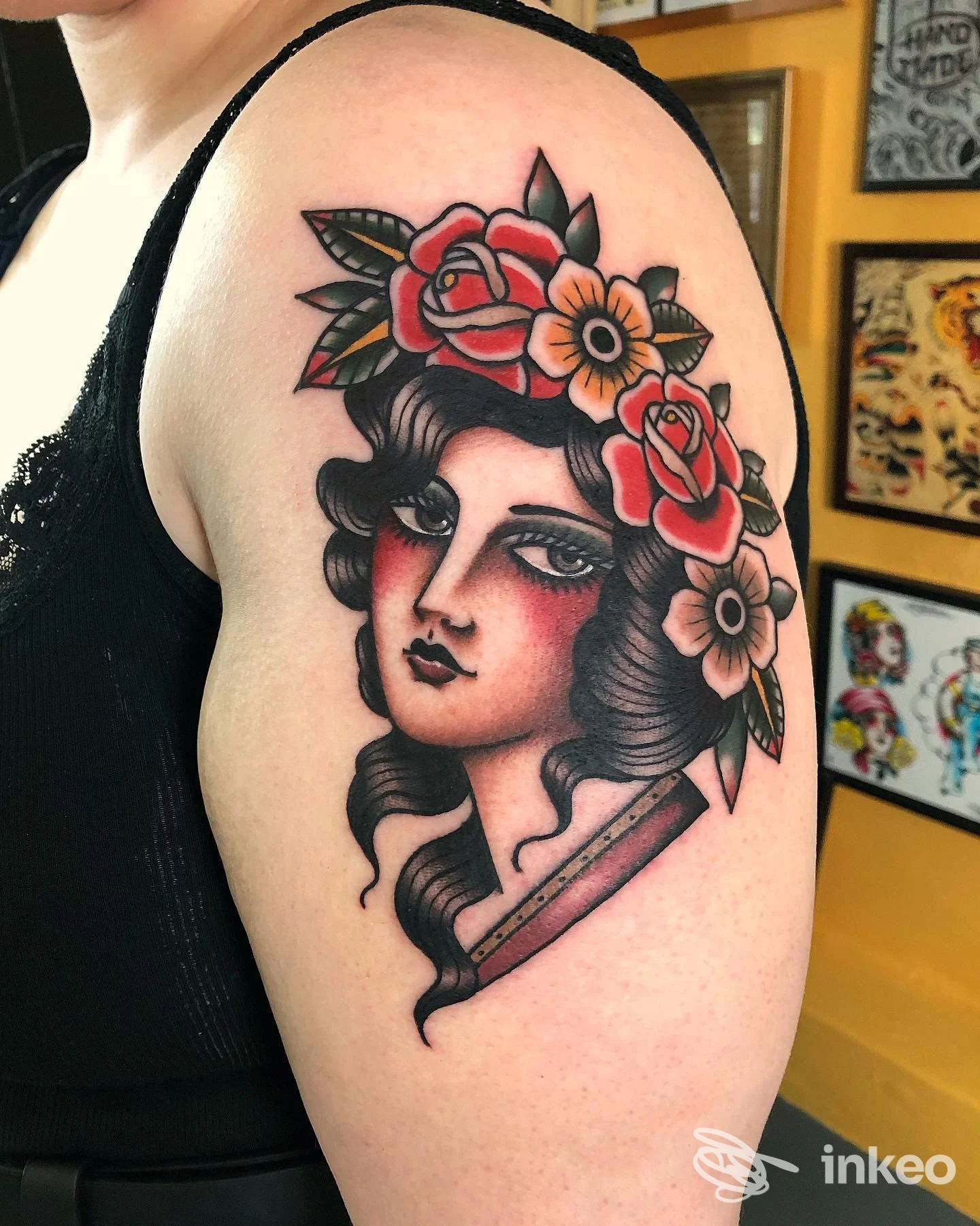 Tatuaggio tradizionale a colori raffigurante volto femminile con corona di fiori sul braccio superiore. Hardtimes Tattoo, Torino.