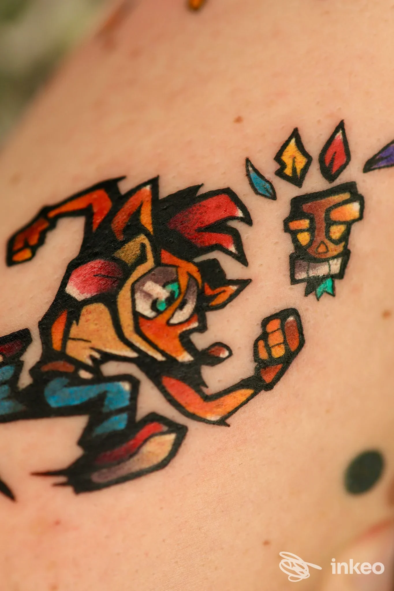 Tatuaggio colorato in stile cartoon sul braccio, con personaggio dinamico e piccolo volto stilizzato, eseguito da IN.SPIRA TATTOO e PIERCING STUDIO a Torino.
