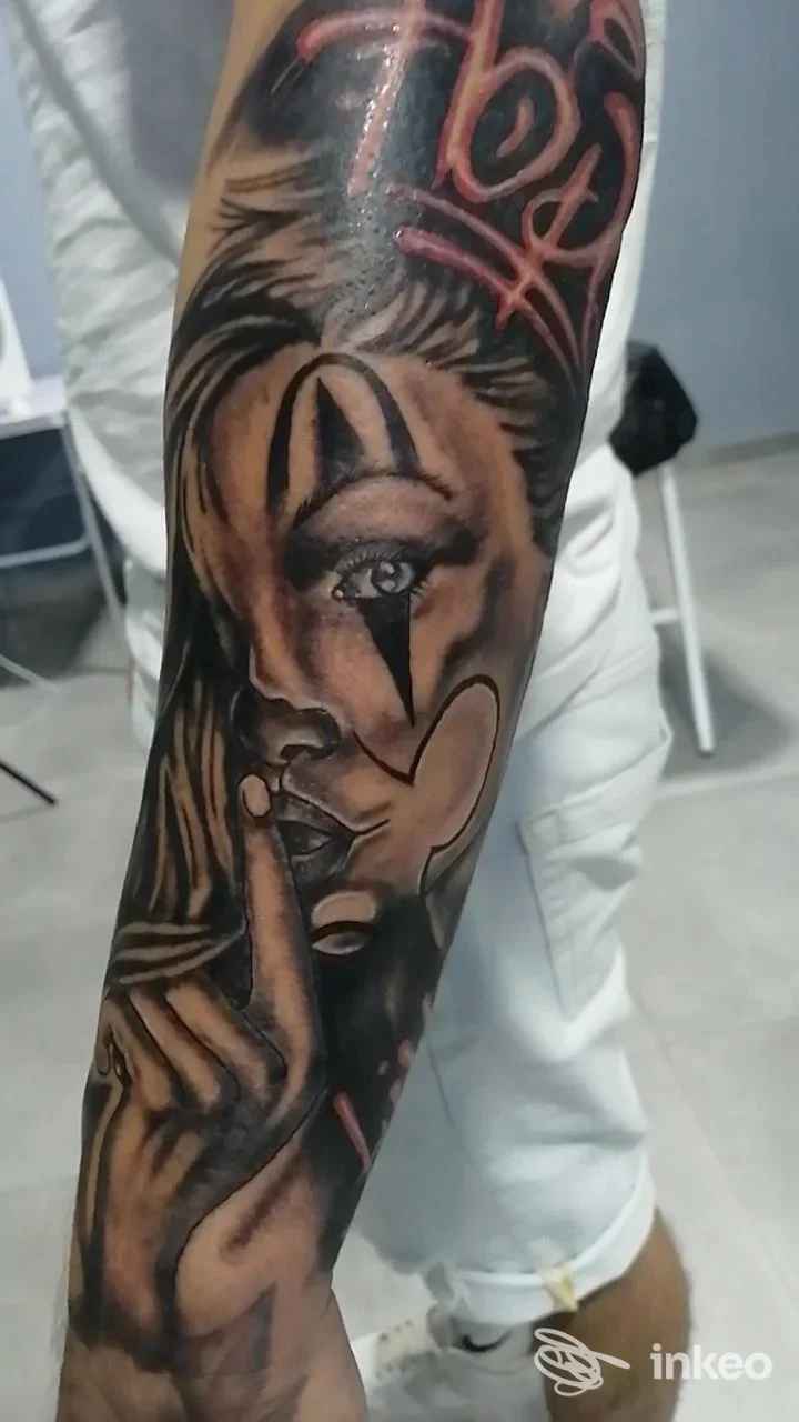 Avambraccio tatuato con volto stilizzato e dettagli realistici, foto inviata per portfolio di IT Tattoo Club, Chivasso.