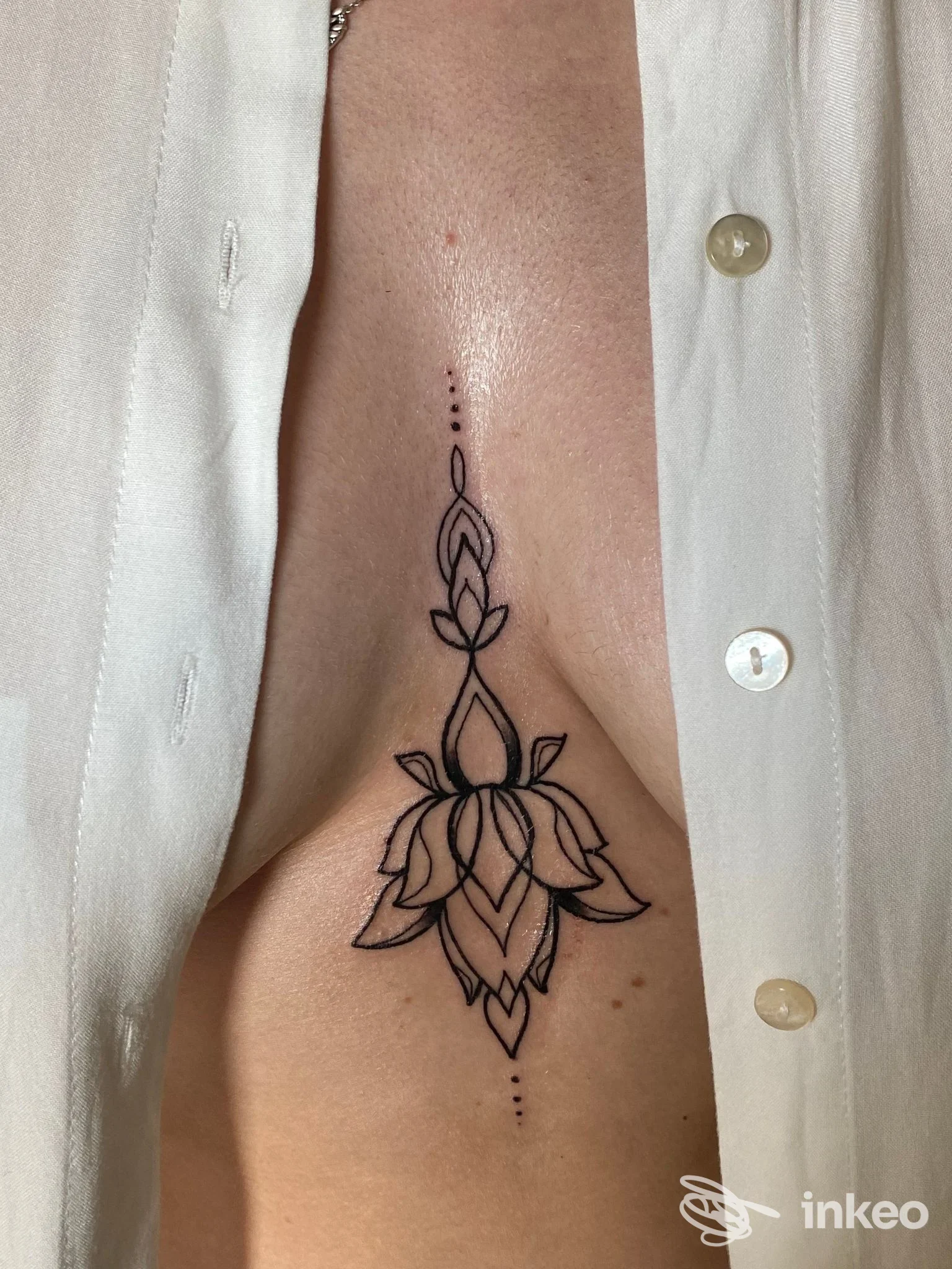 Tatuaggio nero stilizzato al centro del torace/seno, fotografia dello studio Ink world tattoo shop a Centallo.