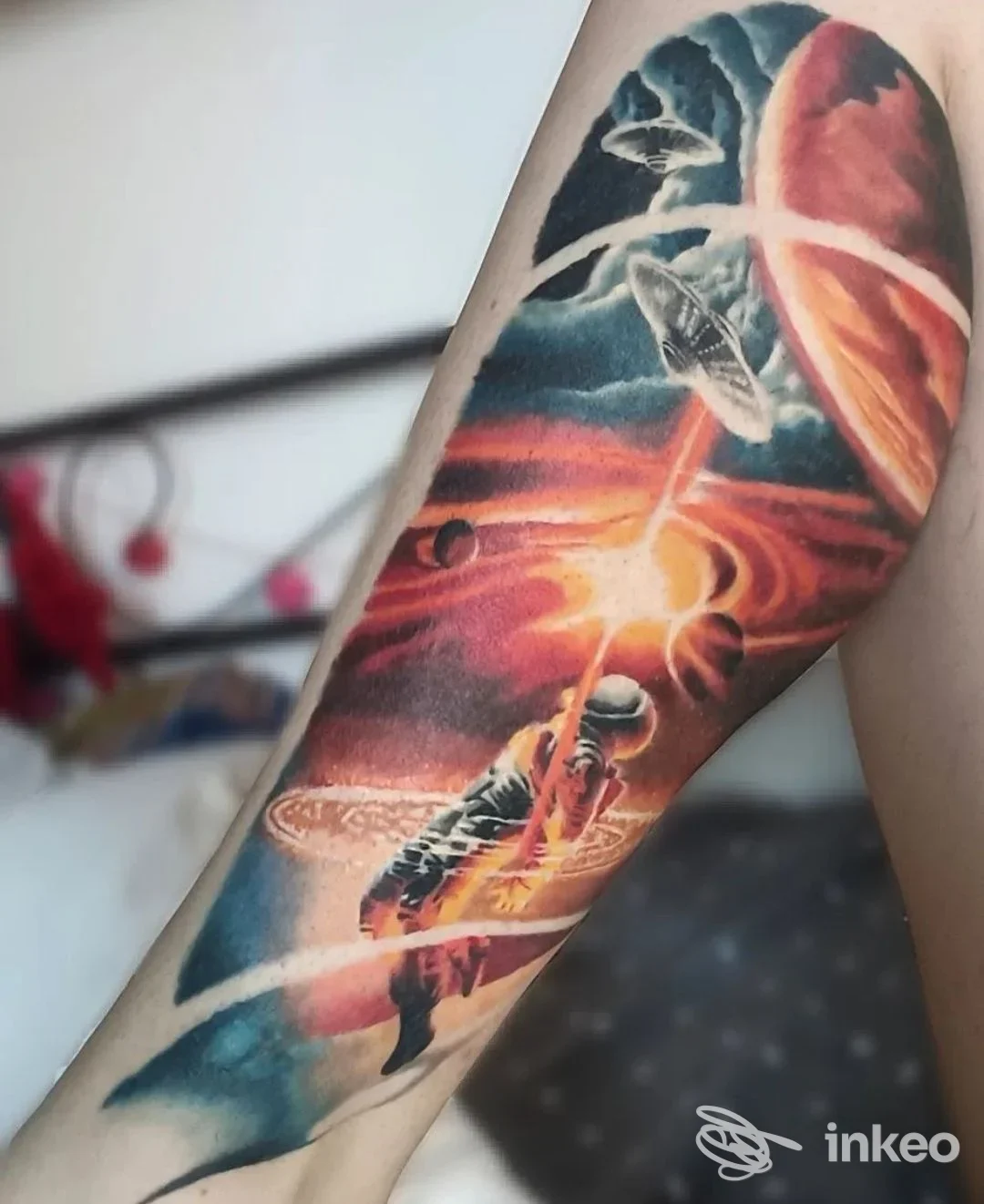 Tatuaggio colorato su avambraccio raffigurante astronauta e pianeti, foto inviata da Inksania Tattoo Shop, Torino.