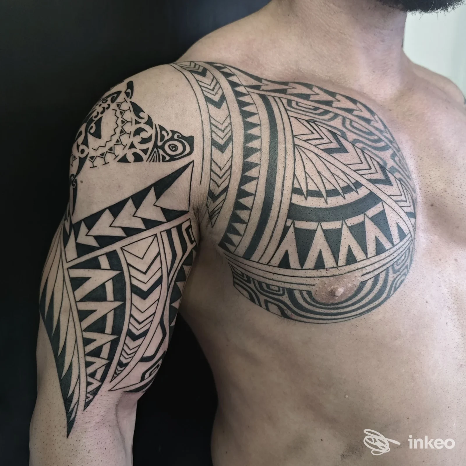 Grande tatuaggio tribale nero su petto, spalla e braccio superiore, foto per Inkside Stories tattoo studio, Moncalieri.