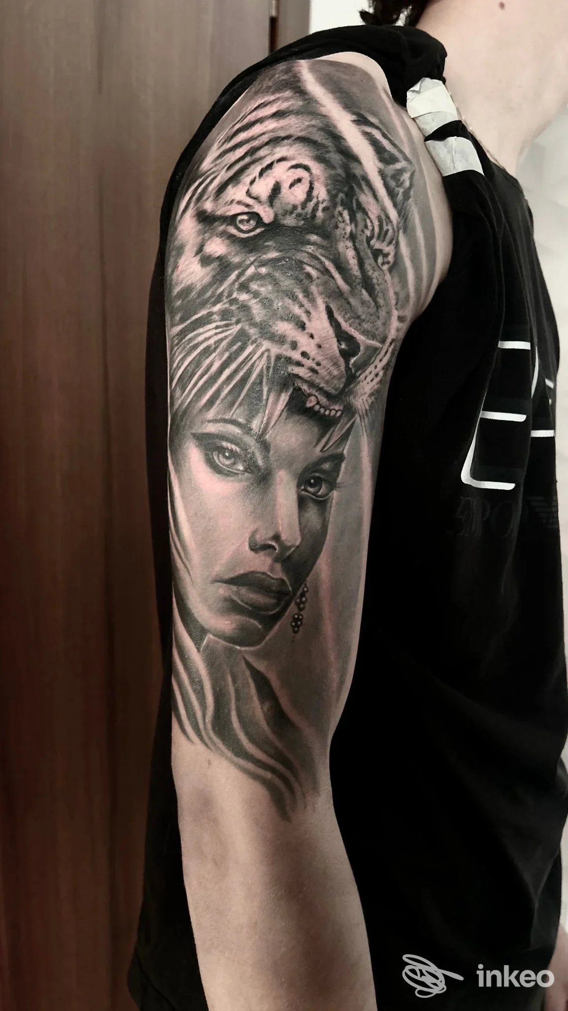 Tatuaggio a mezza manica in bianco e nero con volto femminile e tigre, realizzato da Junior tattoo Cuba a Novara sul braccio.