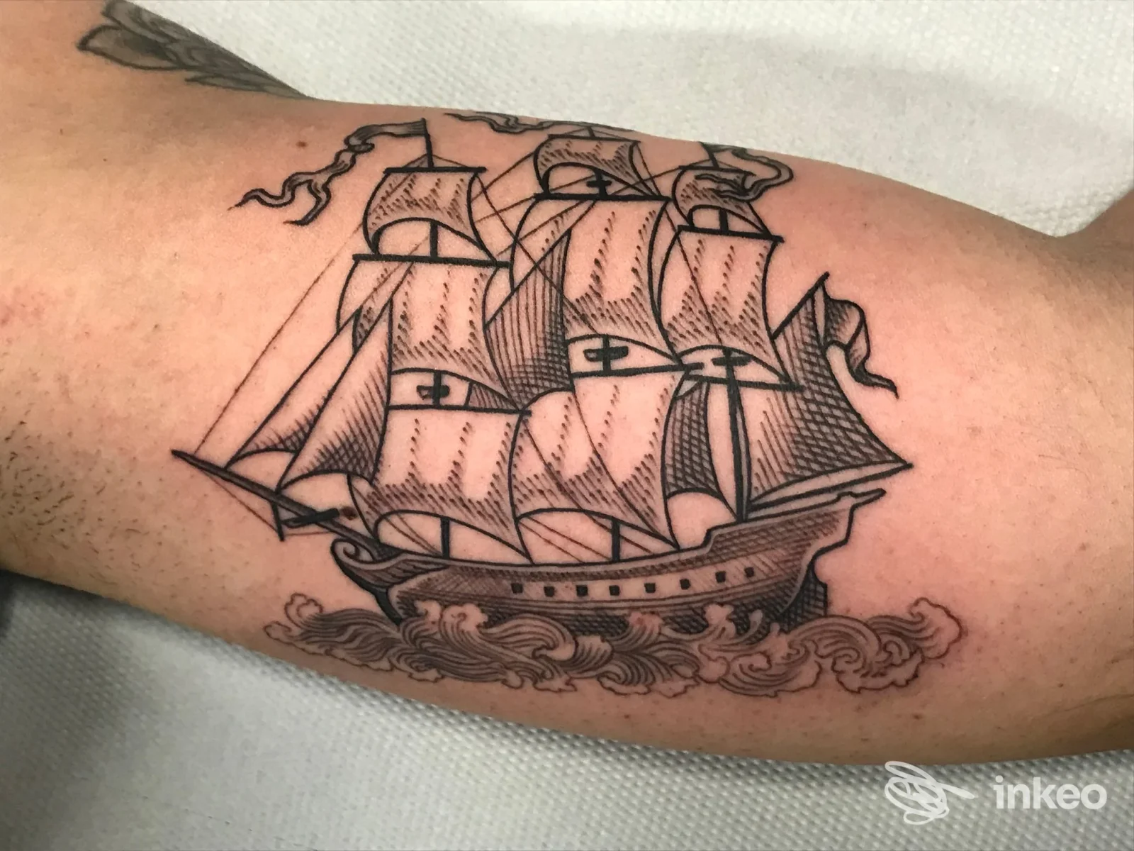 Tatuaggio in nero di una nave a vele con linework e dotwork sull'avambraccio, realizzato da Kalavera Tattoo Studio a Settimo Torinese.