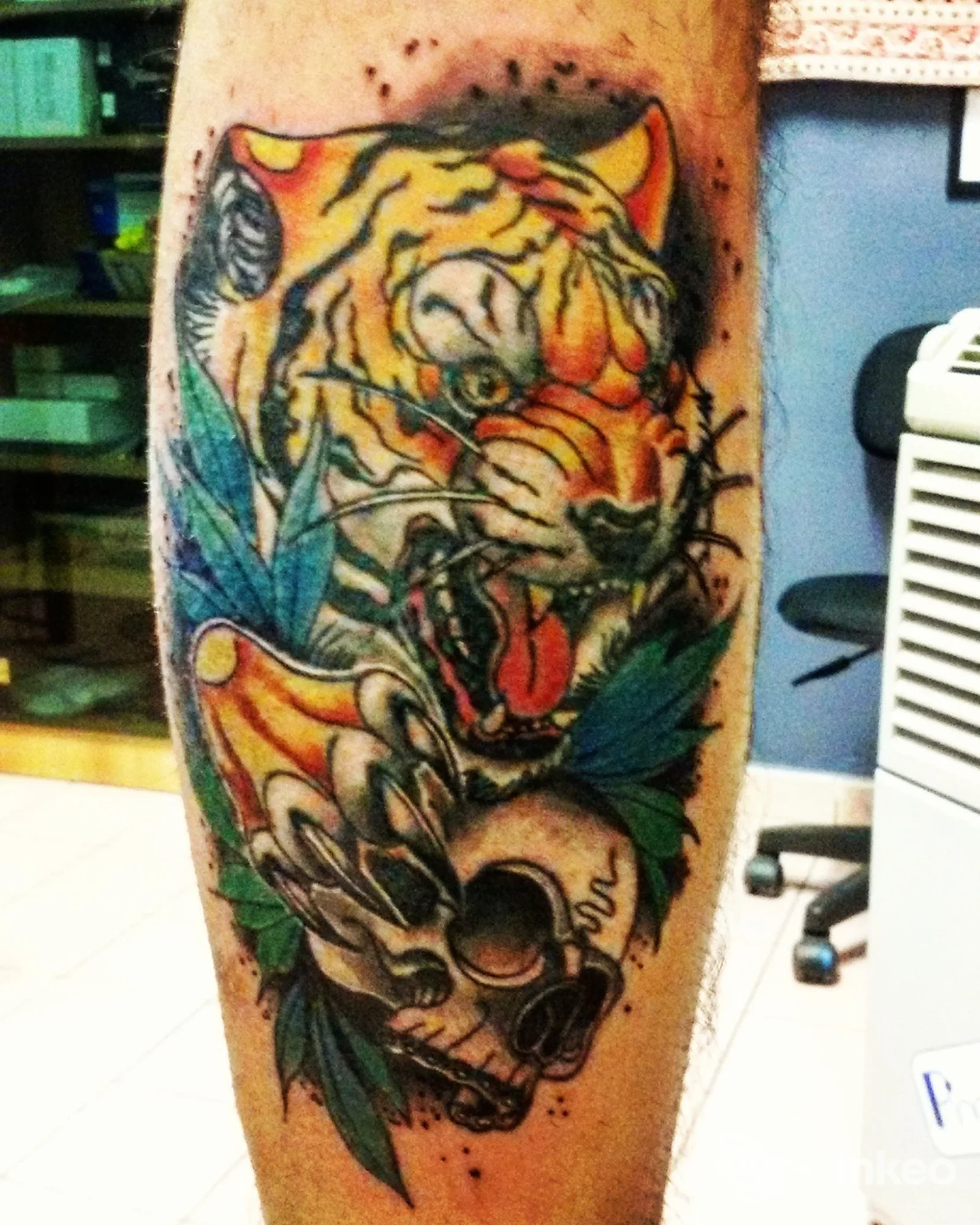 Tatuaggio su polpaccio: tigre colorata con teschio e foglie, lavoro fotografato allo studio LA VALLE DI LACRIME TATTOO, Buttigliera Alta.