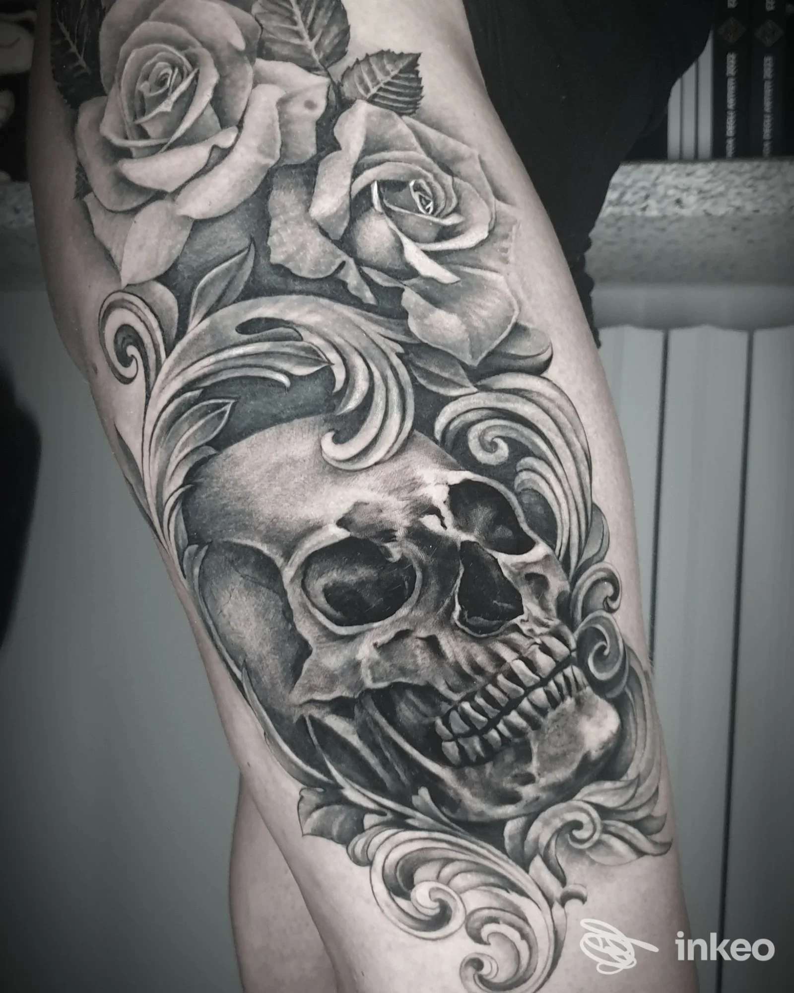 Tatuaggio black & grey su coscia con teschio, volute ornamentali e rose — La Scimmia Tatuata, Landiona.