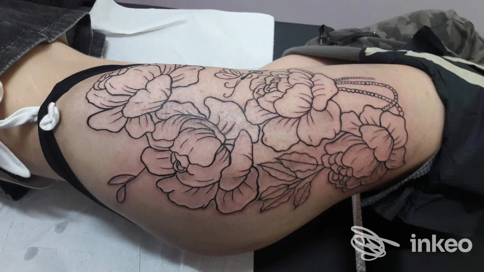 Tatuaggio floreale a contorno sull'esterno coscia, realizzato da Madison Tattoo Torino a Torino.