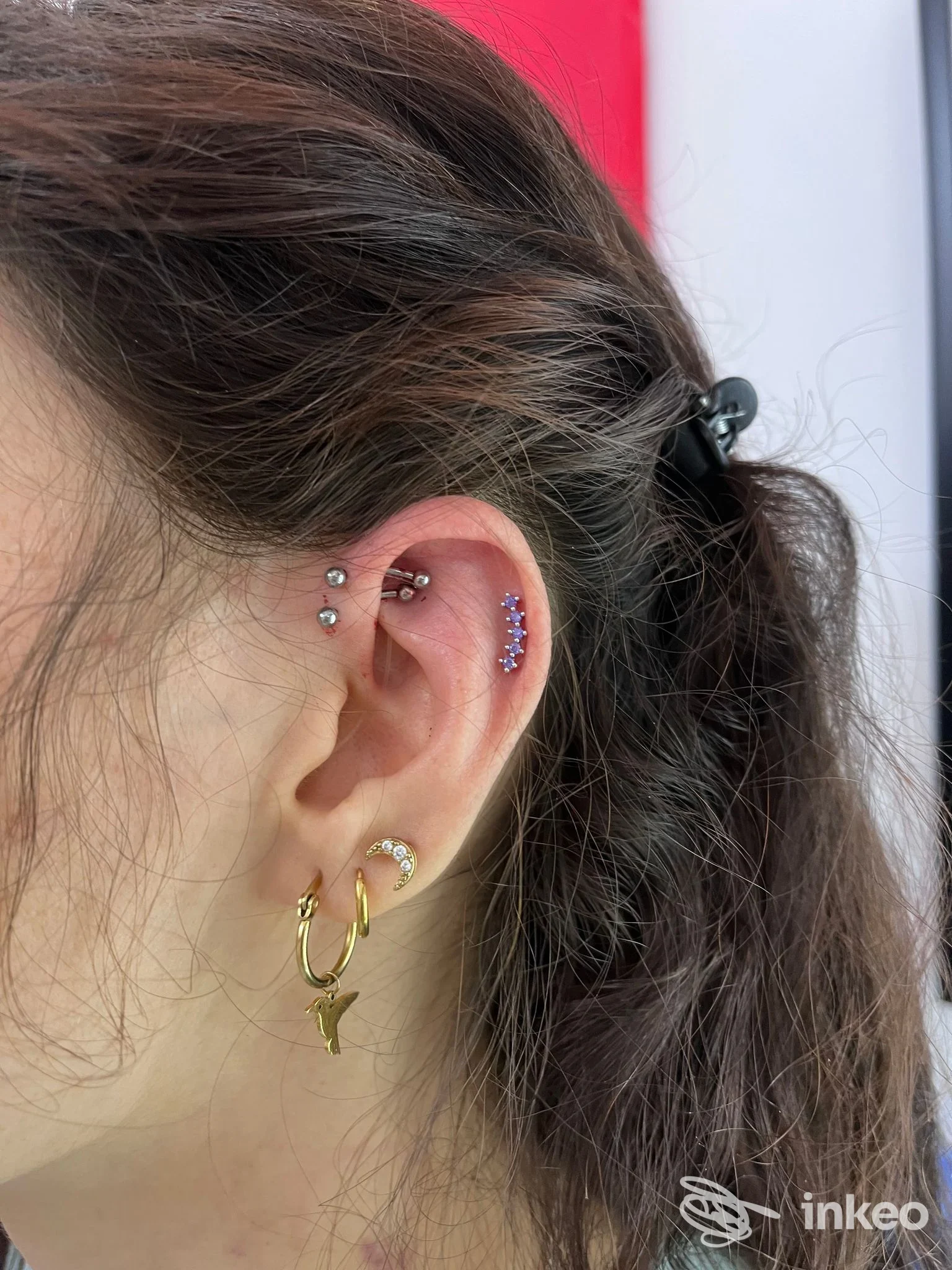Orecchio con più piercing professionali (helix, tragus e lobo) eseguiti da Maargotz Body Piercing, Domodossola.
