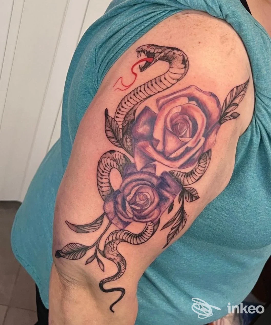 Tatuaggio di serpente e rose sul braccio superiore, realizzato da Manu Tattoo Ink a Poirino, dettagli in nero e ombreggiature.