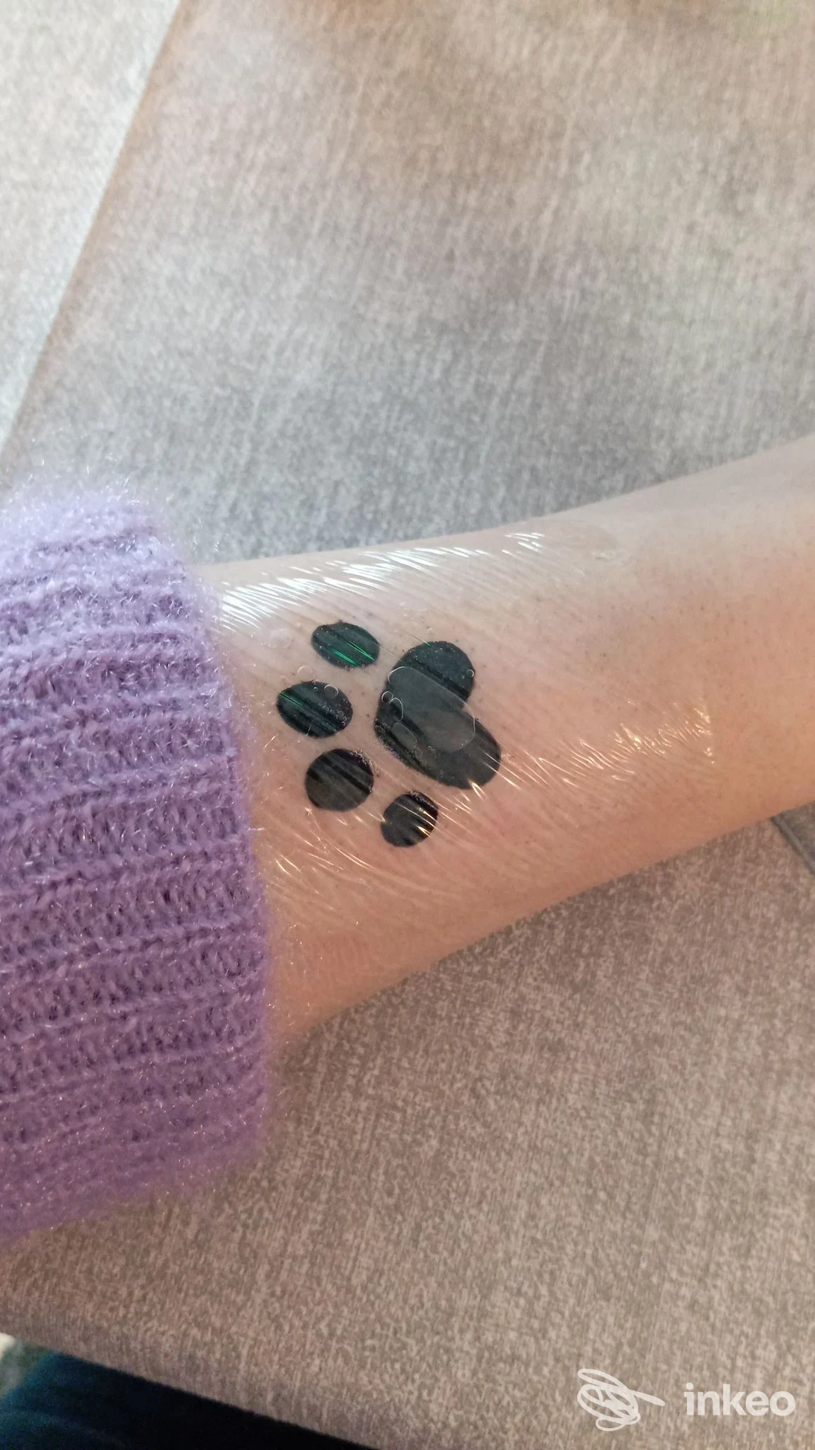 Primo piano di un tatuaggio a impronta sull'avambraccio avvolto in pellicola, Maschè Tattoo & Piercing, Torino.