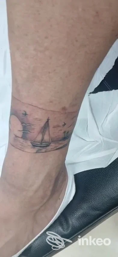 Dettaglio di tatuaggio a barca a vela sulla caviglia, fotografia inviata da Maschè Tattoo & Piercing, Torino.