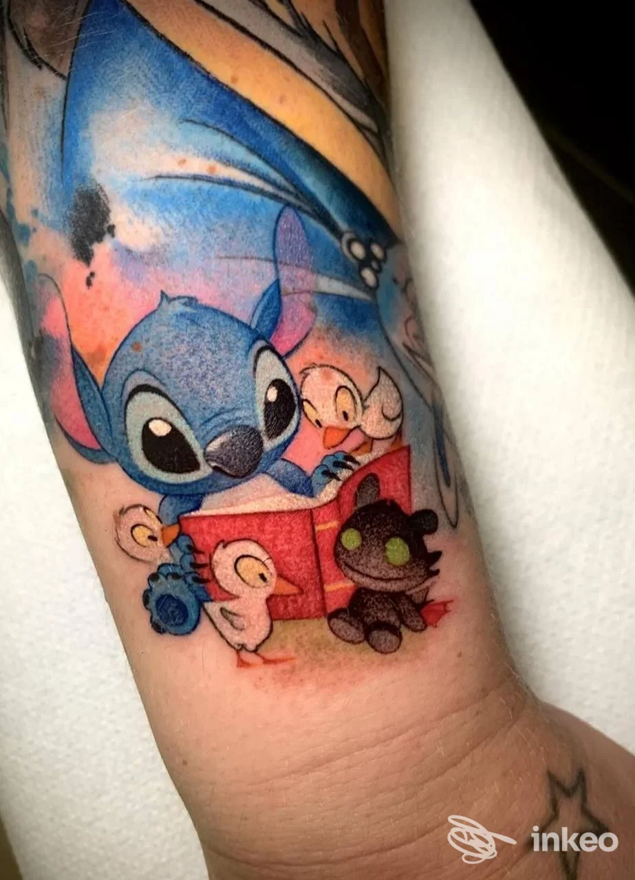 Tatuaggio colorato su avambraccio con Stitch che legge un libro e piccoli pulcini — Mek&phebe Tattoo, Cuneo.