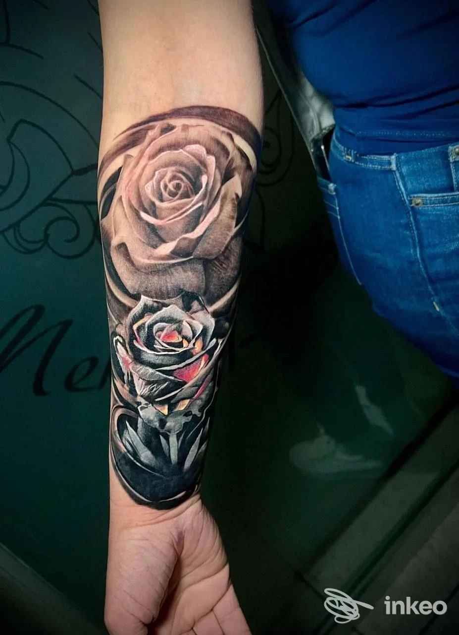 Tatuaggio realistico di rose in bianco e nero con tocchi rosa sull'avambraccio, foto fornita da Mek&phebe Tattoo, Cuneo.