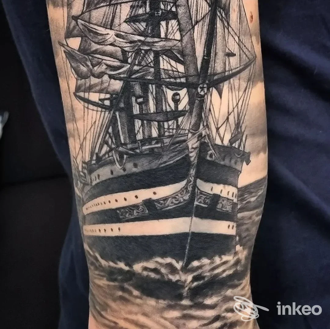 Tatuaggio realistico in bianco e nero di una grande nave a vela sull’avambraccio, opera dello studio Nivida Tattoo, Torino.