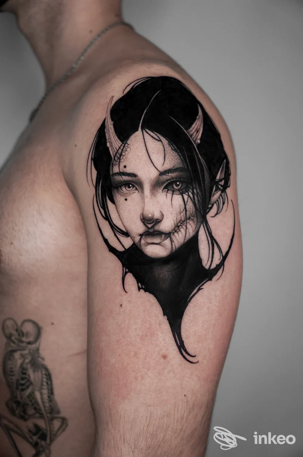 Tatuaggio a figura femminile in nero sulla spalla superiore di un uomo, foto per Oltrenero Studio Tatuaggi, Torino.