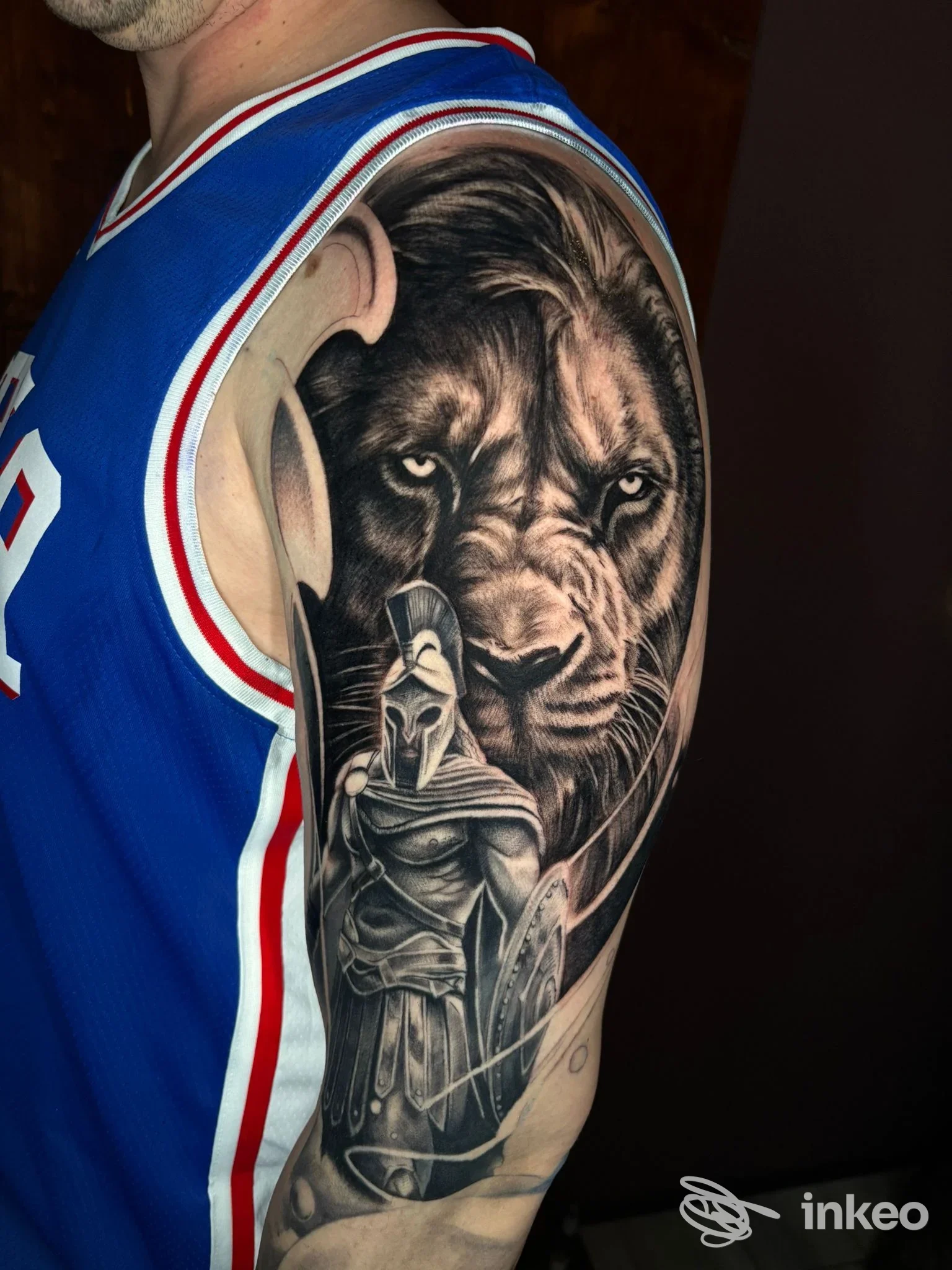 Large tatuaggio realistico a manica su braccio superiore con leone e guerriero, foto dallo studio Orgoglio & Pregiudizio Tattoo Studio, Cameri.