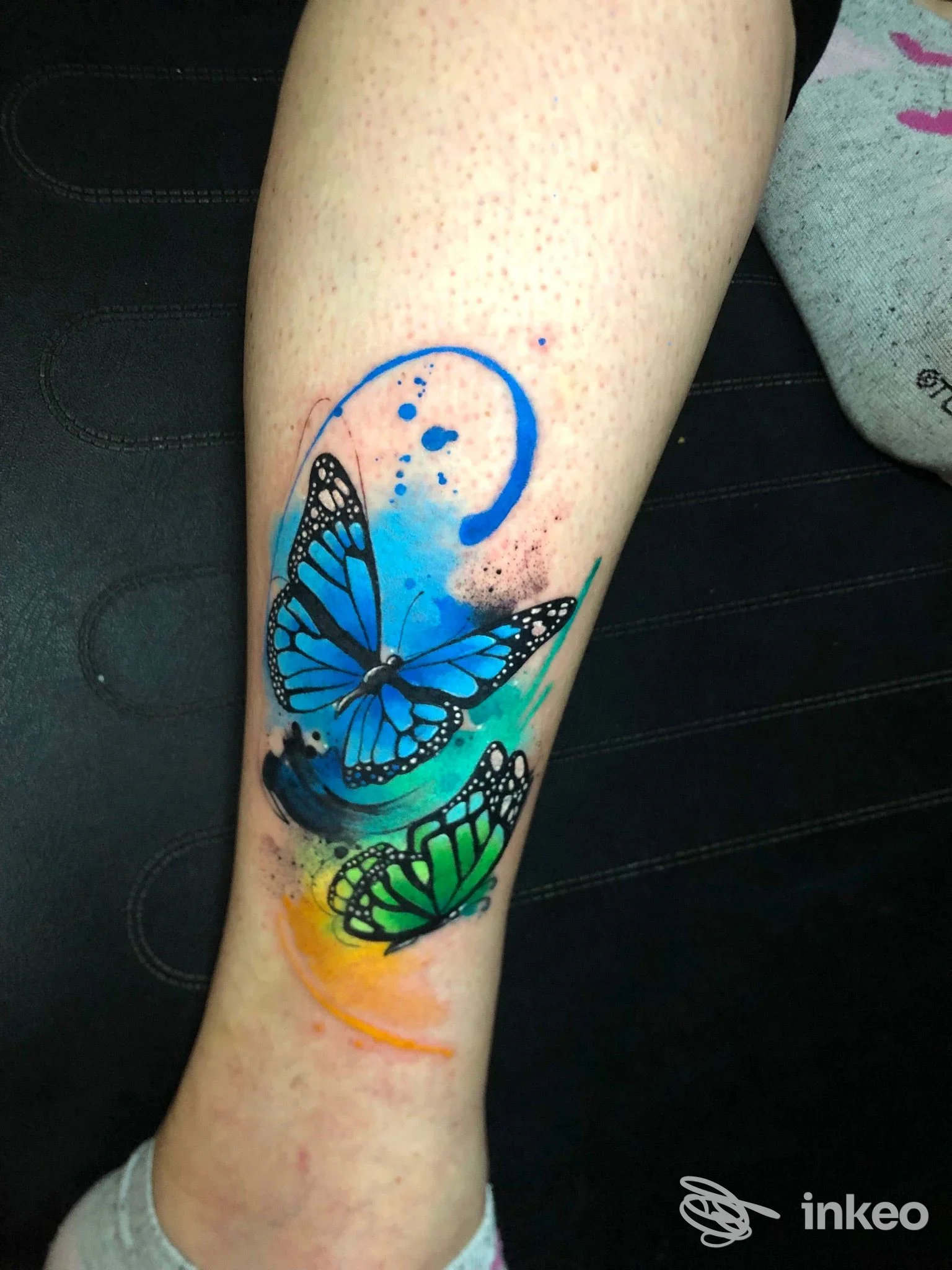 Farfalle colorate in stile acquerello tatuate sul polpaccio, blu e verde con dettagli neri — Orgoglio & Pregiudizio Tattoo Studio, Cameri.