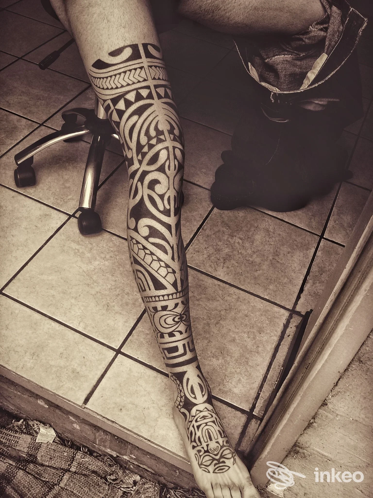 Gamba e piede tatuati con motivo tribale in nero, fotografia da Pischy Tattoo, Torino.