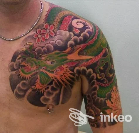 Grande tatuaggio a colori di drago su spalla e petto maschile, realizzato da Renato Doctortattoo a Moncalieri.