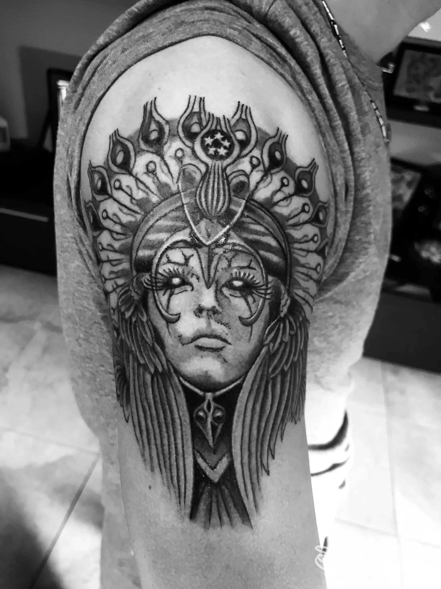 Tatuaggio realistico in bianco e nero sul braccio alto con figura femminile stilizzata e decorazioni, realizzato da Renato Doctortattoo a Moncalieri.