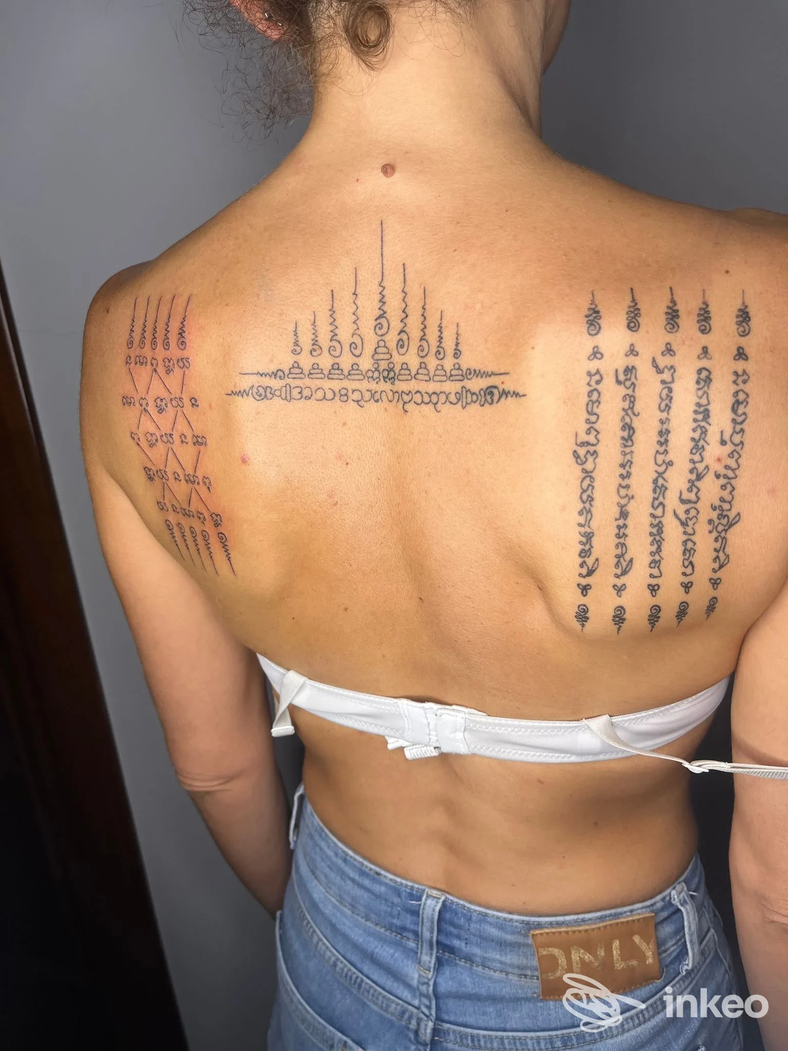 Parte superiore della schiena con tre tatuaggi neri decorativi; foto fornita da Rosegold Tattoo, Chivasso.