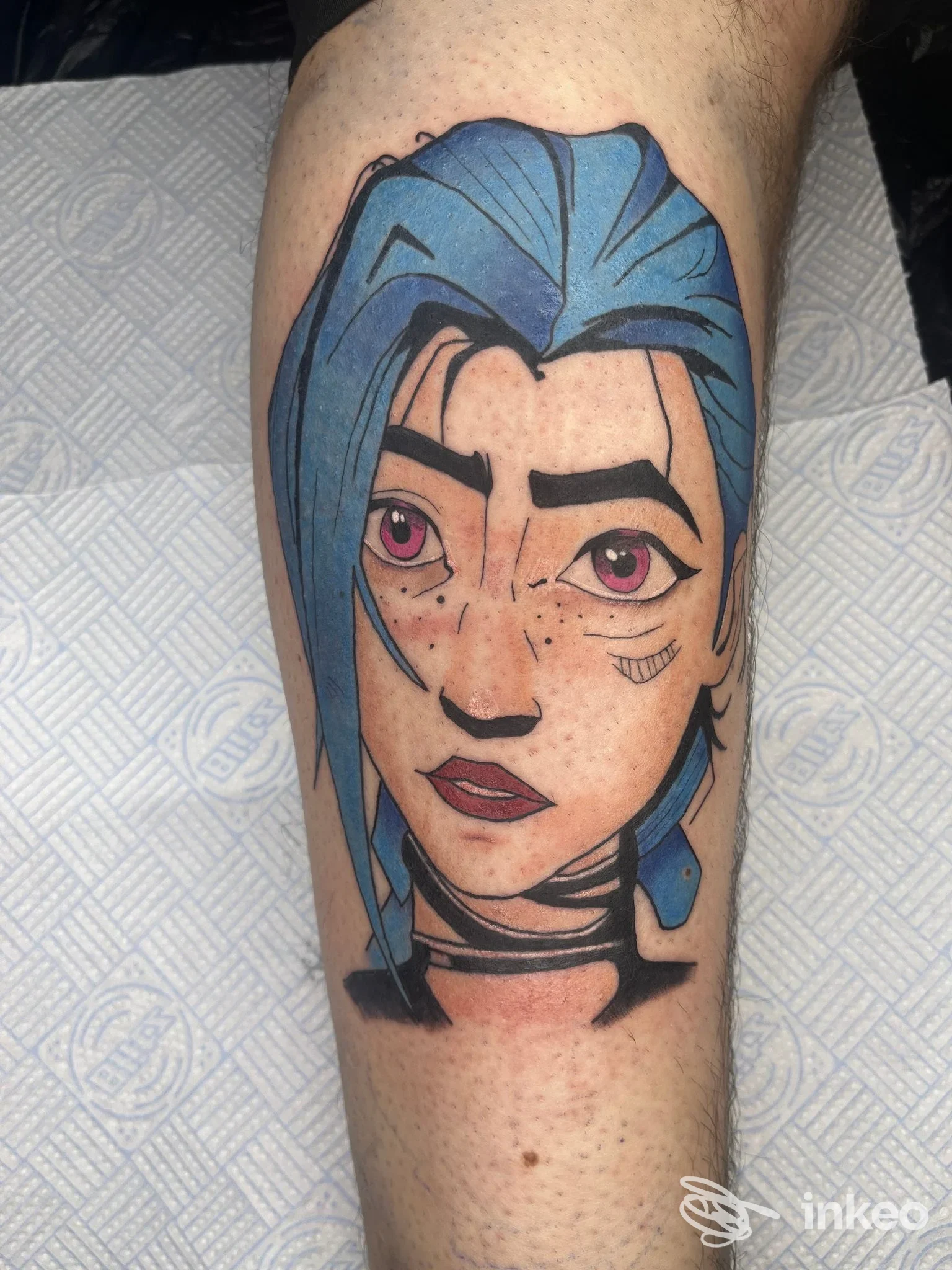 Tatuaggio figurativo sul polpaccio raffigurante un volto con capelli blu, Rosegold Tattoo a Chivasso.