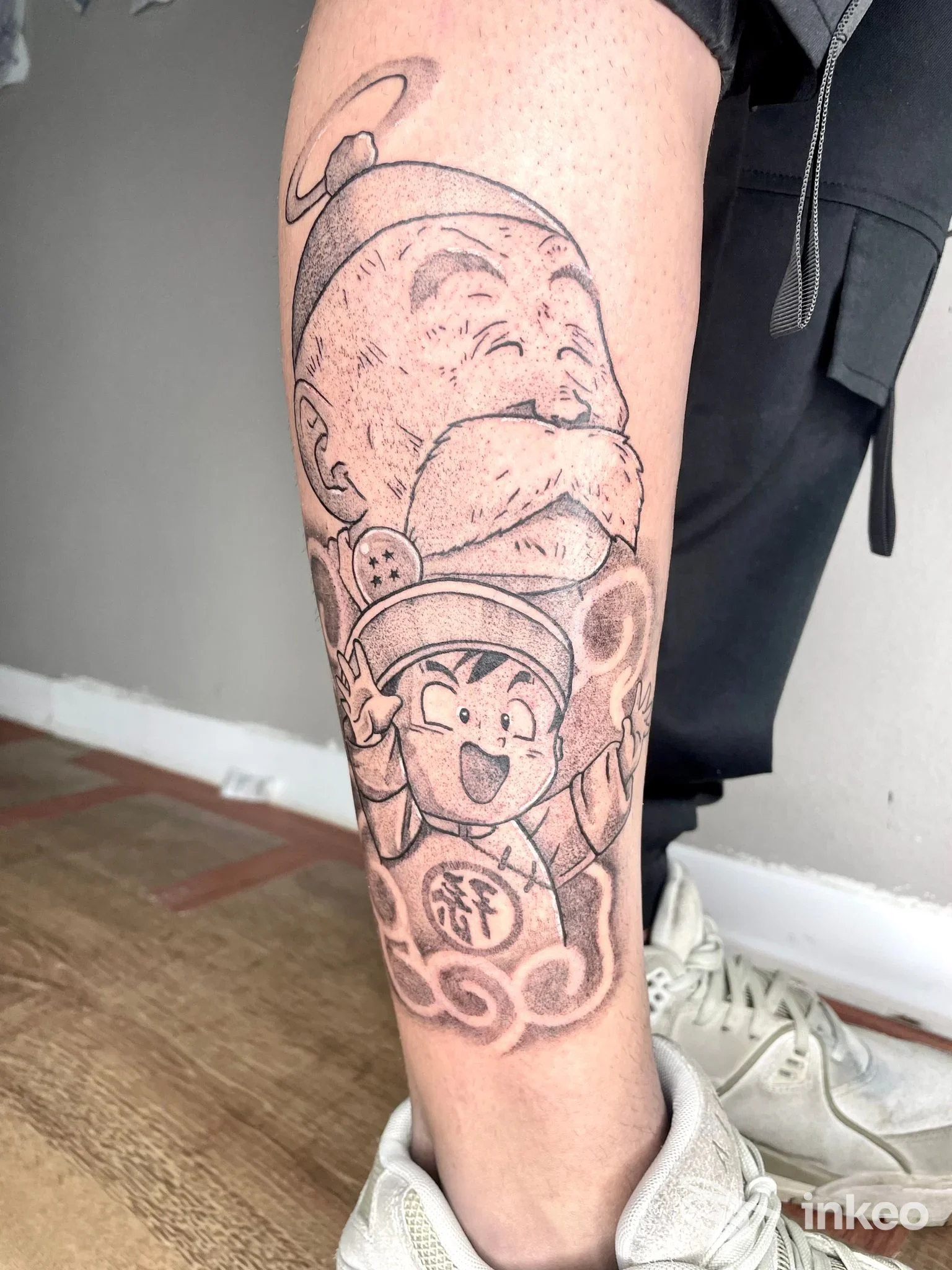 Tatuaggio in bianco e nero sul polpaccio, raffigurante personaggi in stile cartoon — OTTANT8 studio tattoo, Alessandria.