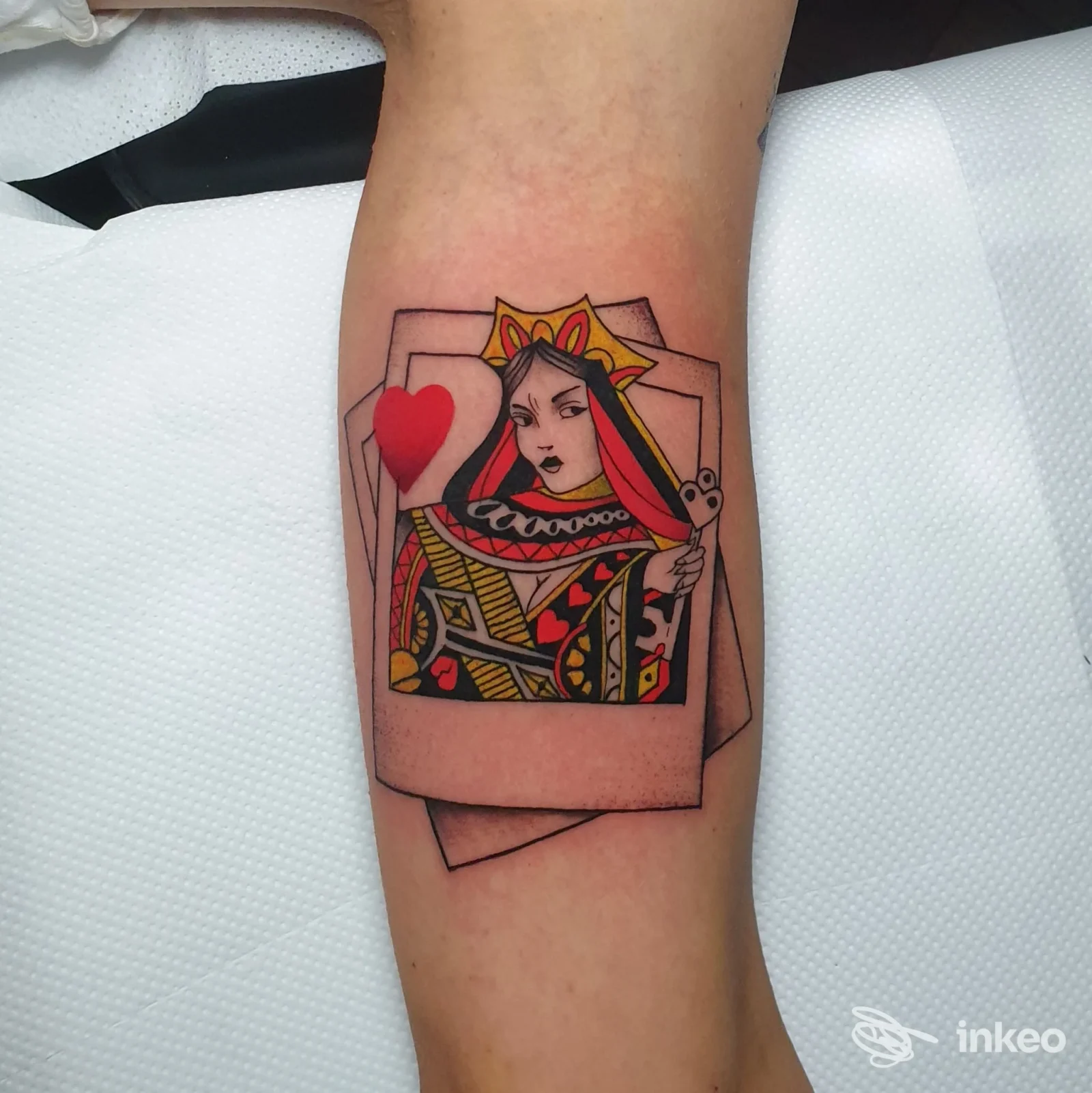 Tatuaggio stilizzato della Regina di cuori su avambraccio, linee nette e colori pieni. Red Pant Tattoo & Piercing, Crescentino.