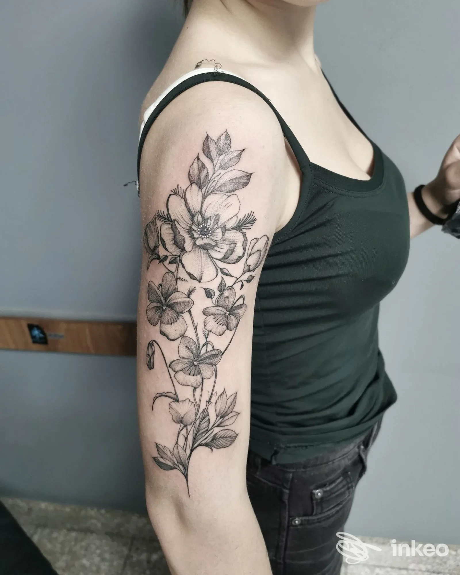 Tatuaggio floreale in bianco e nero sul braccio superiore, foto fornita da Rox Tattoo Team - Torino.