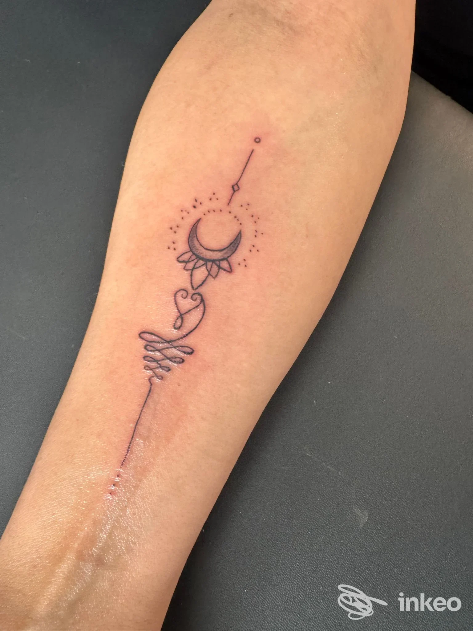 Piccolo tatuaggio lineare sull'avambraccio interno con luna e motivi ornamentali. Foto di Saretta Tattoo & Murales, Cuorgnè.