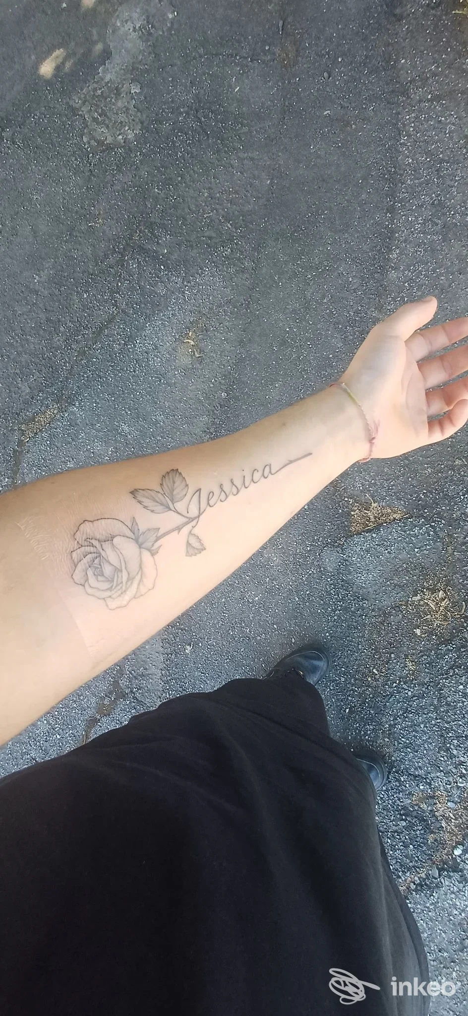 Primo piano dell'avambraccio con tatuaggio nero a rosa e la scritta 'Jessica'. Immagine fornita da SharINK TATTOO studio, Trecate.