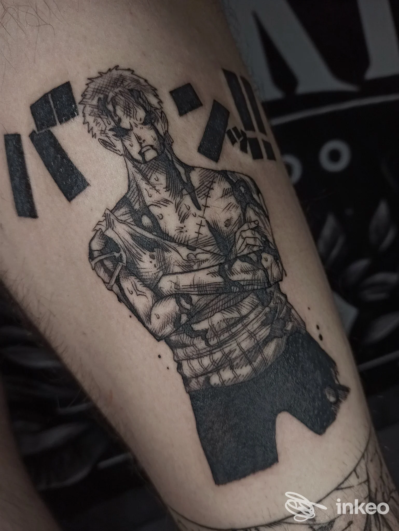 Primo piano di un tatuaggio blackwork su avambraccio che raffigura un personaggio stilizzato. Skull & Fox Tattoo Studio, Biella.