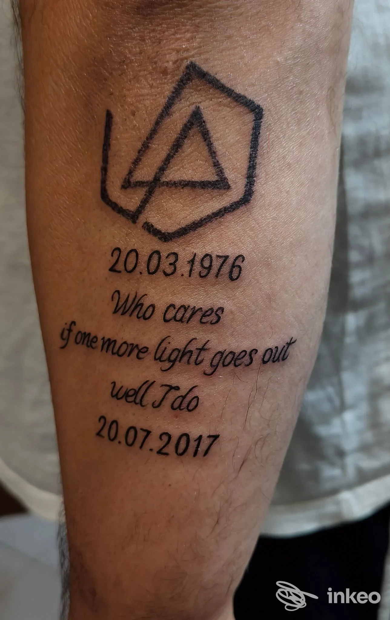 Tatuaggio in inchiostro nero su avambraccio con simbolo geometrico e testo datato, realizzato da Skyline Tattoo a Vercelli.