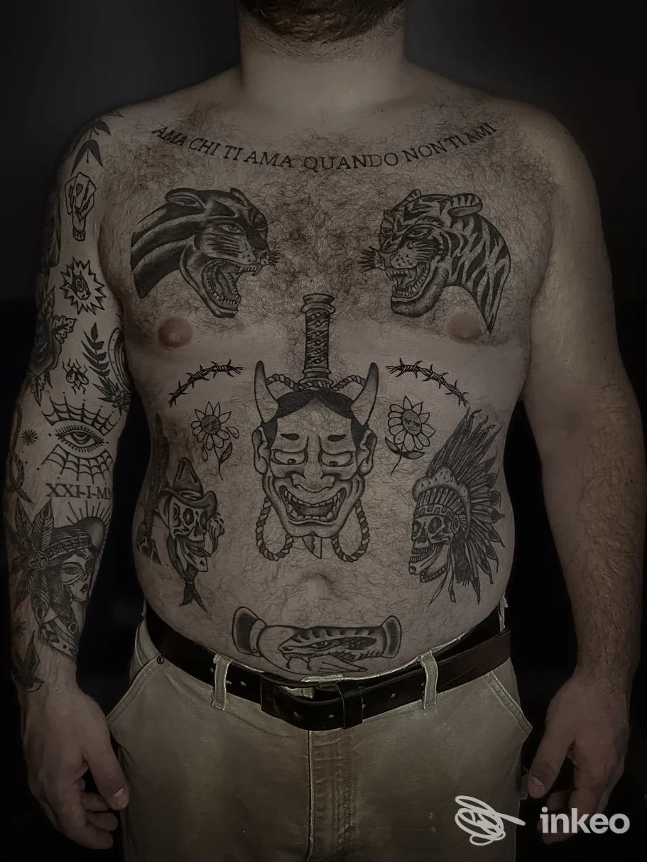Petto e braccia tatuati su uomo adulto con diversi soggetti in nero; foto fornita dallo studio Speakeasy Tattoo Club, Torino.