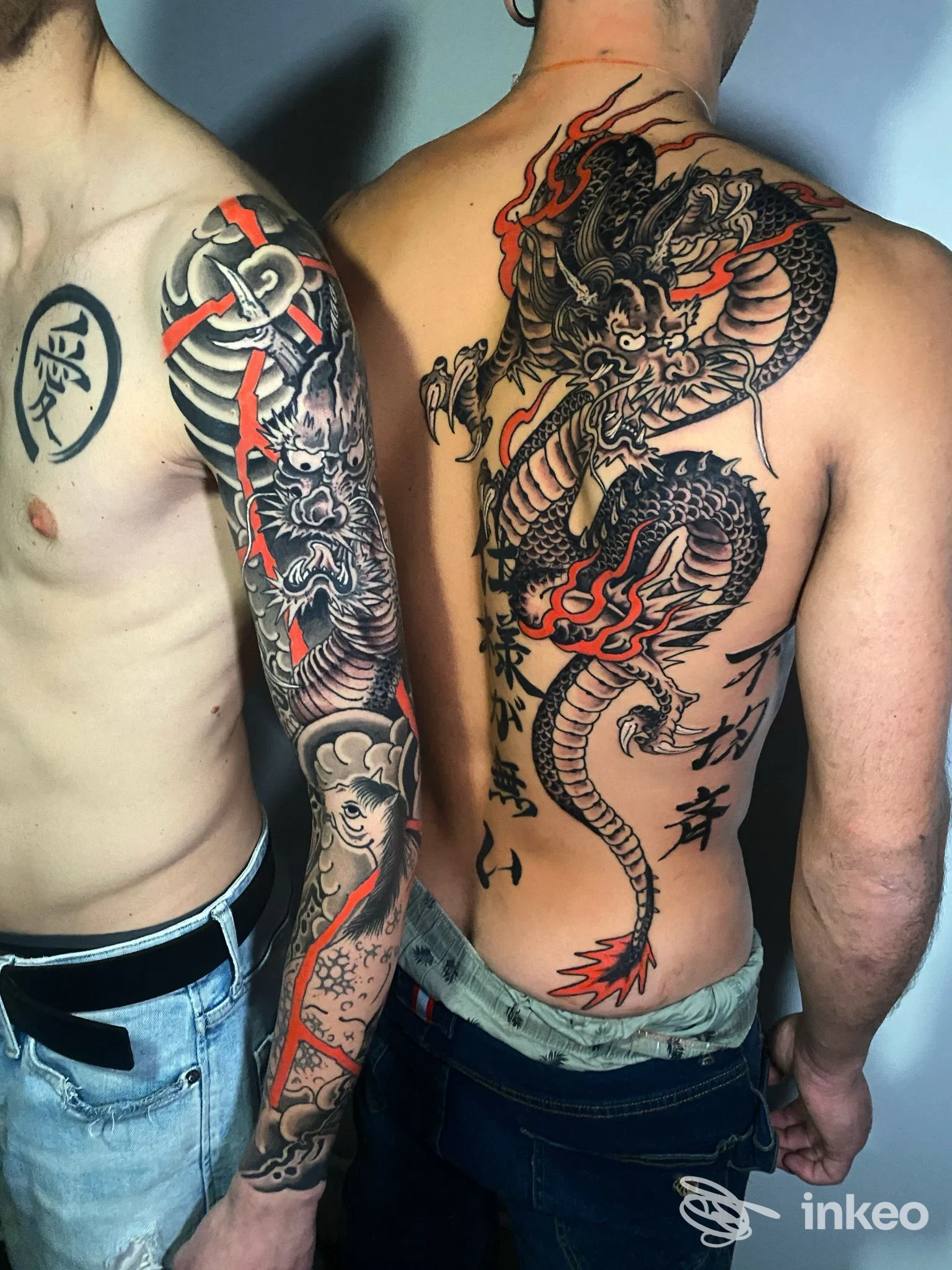 Due uomini con tatuaggi: manica completa sul braccio sinistro e grande drago sulla schiena. Spot - Graffiti Tattoo Shop, Torino.