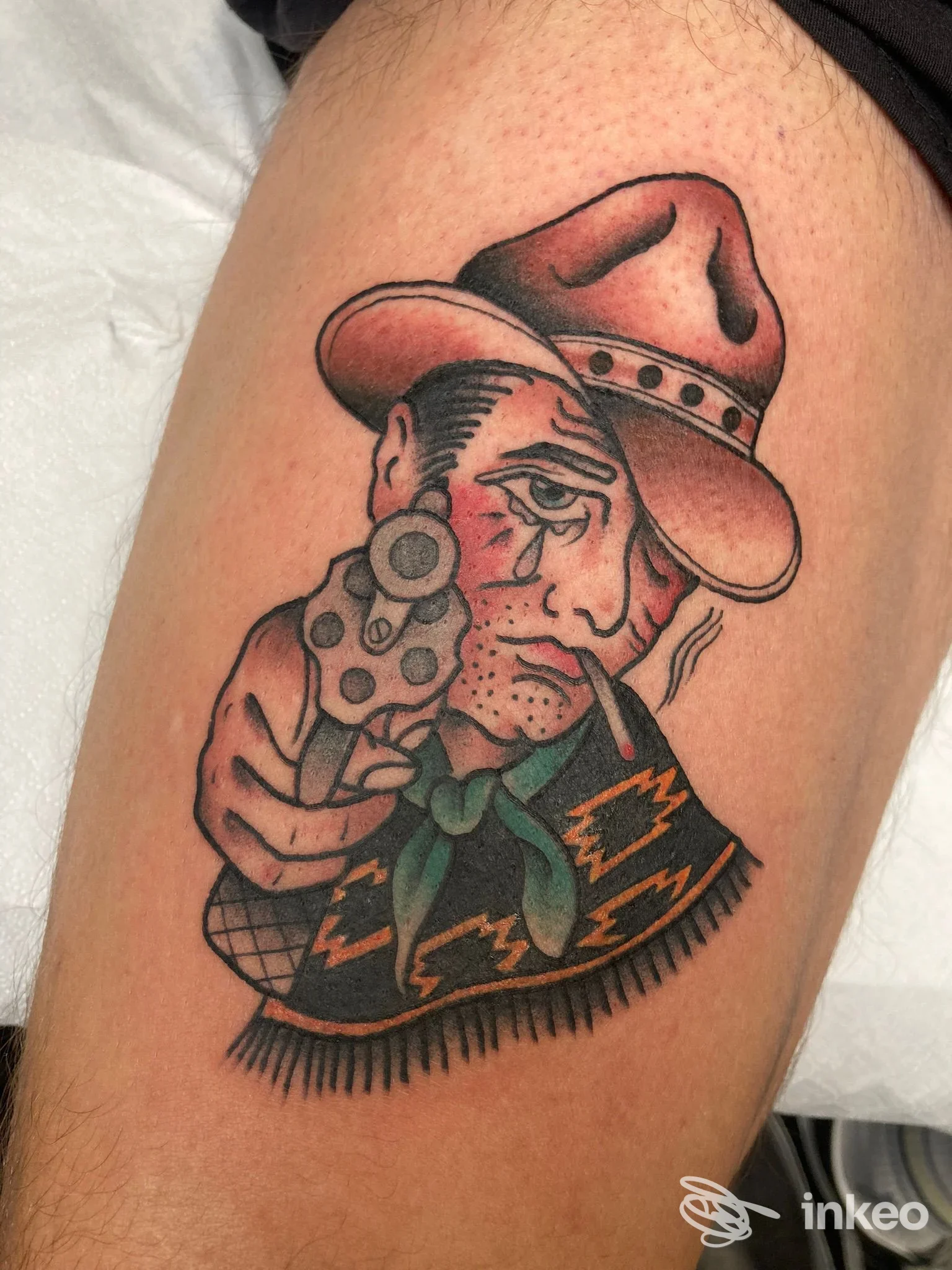 Tatuaggio tradizionale su coscia: uomo con cappello e pistola, foto fornita da SPINE Tattoo Lab, Torino.