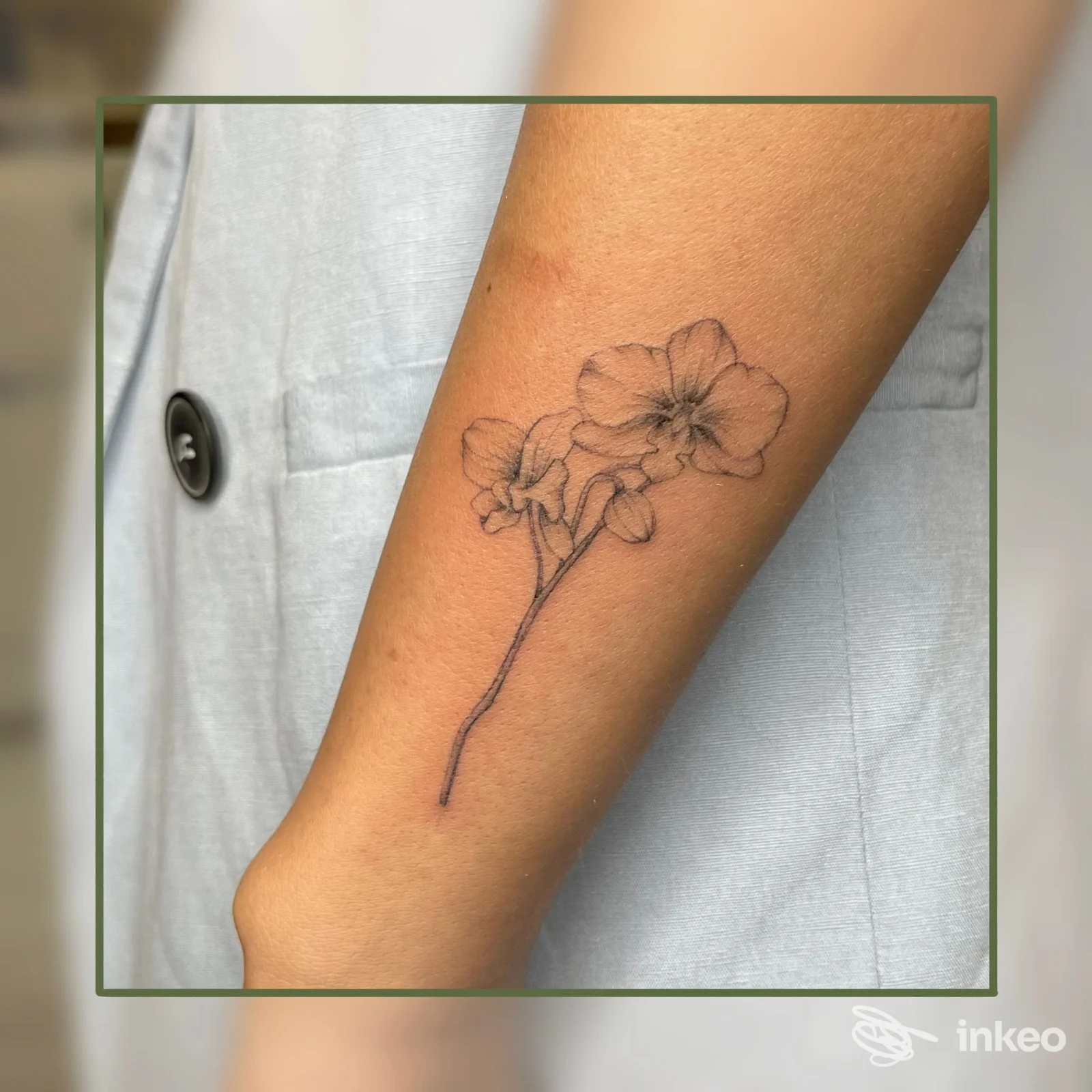 Piccolo tatuaggio a linee sottili di un ramo fiorito sull'avambraccio, lavoro realizzato da Salvia Tattoo a Vigone.