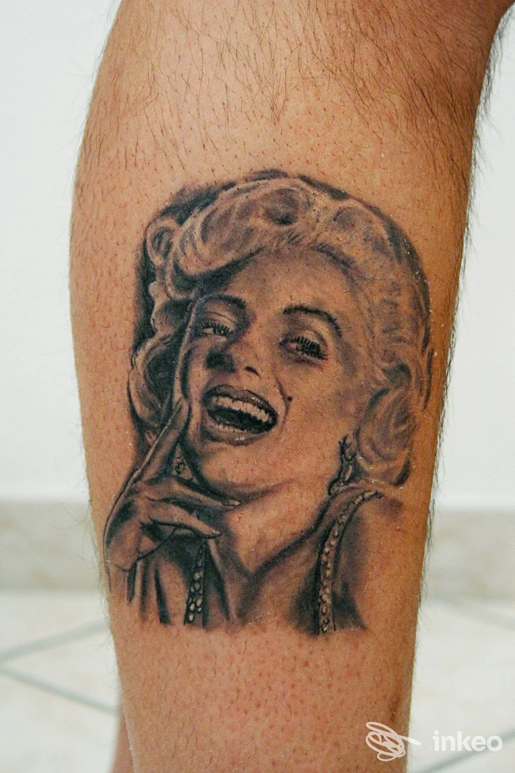 Ritratto tatuato in bianco e nero su polpaccio, realizzato da TATUAGGI ARTISTICI VERBANIA TATTOO STUDIO a Pallanza.