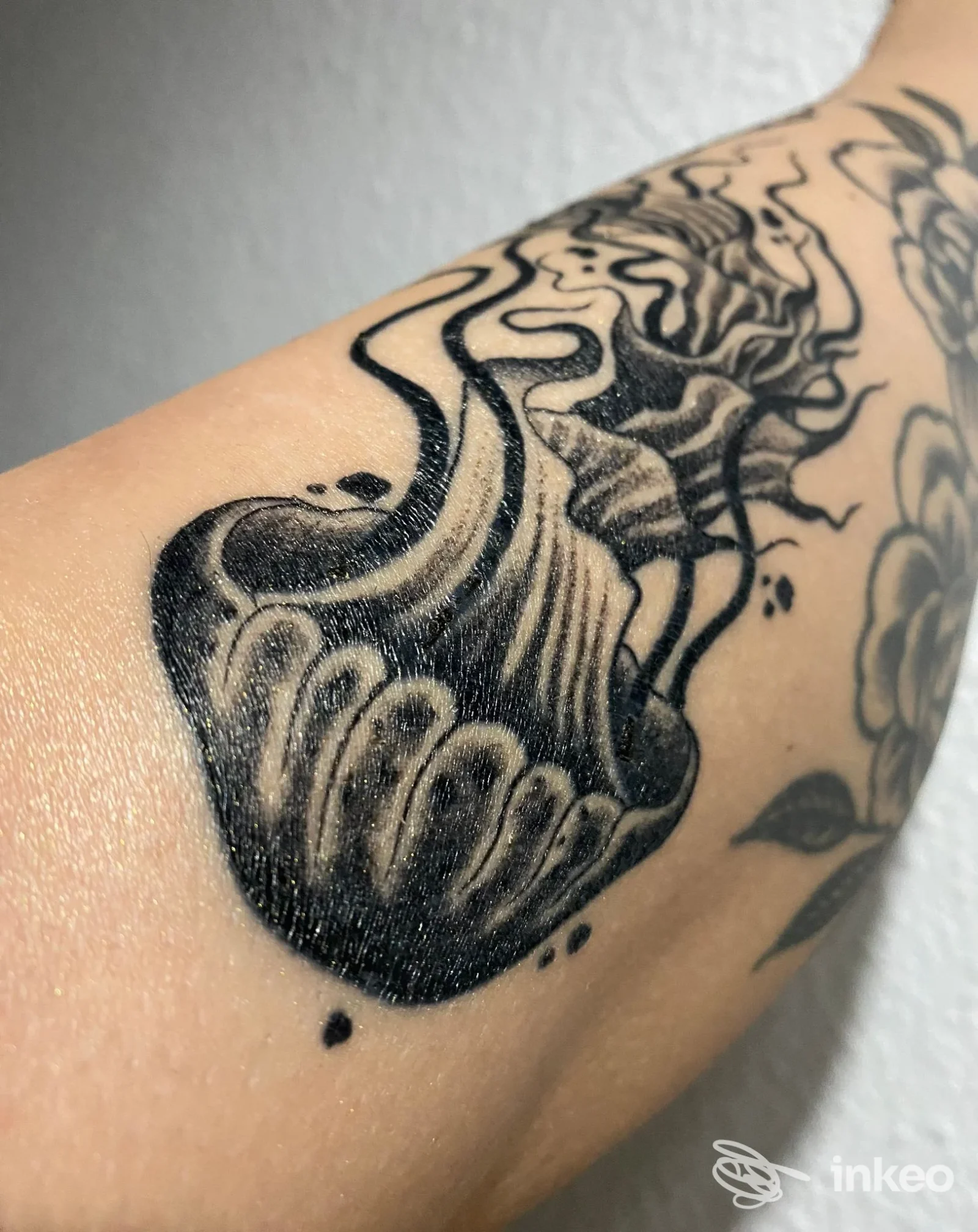Tatuaggio nero in stile ink su pelle, raffigurante un disegno scuro di chiaro contrasto, visibile su braccio, senza volto né elementi di interfaccia. Studio Borderline Tattoo Studio, Germignaga.