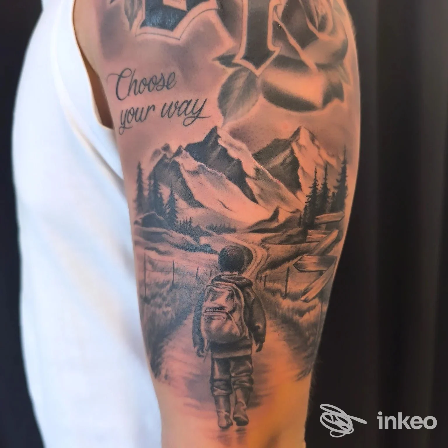 Tatuaggio black & grey con paesaggio montano e viandante sul braccio, Tauro Tattoo Studio Collegno.
