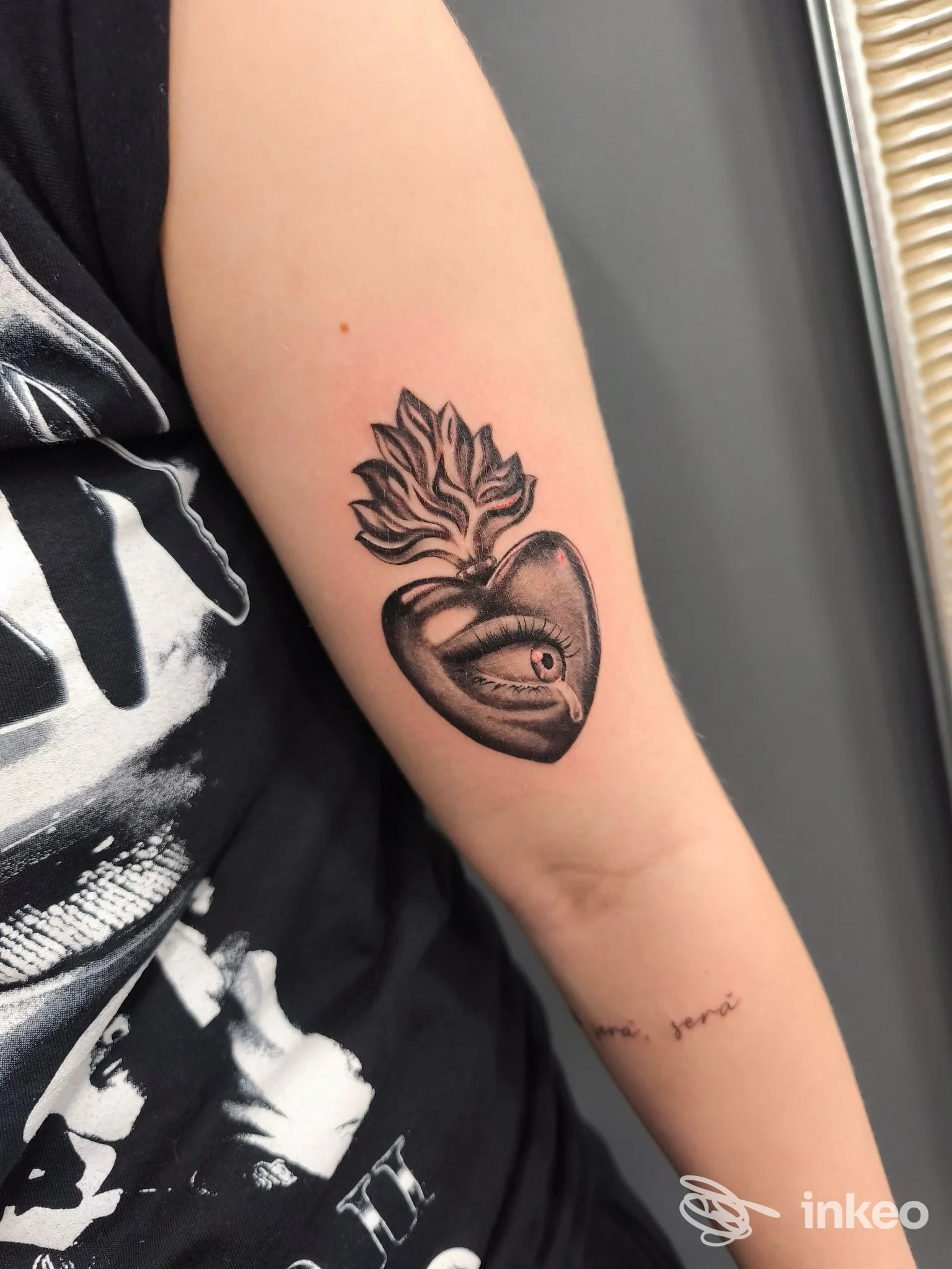 Tatuaggio su avambraccio interno: cuore stilizzato con un occhio e fiamma sopra, realizzato da Tauro Tattoo Studio a Collegno.