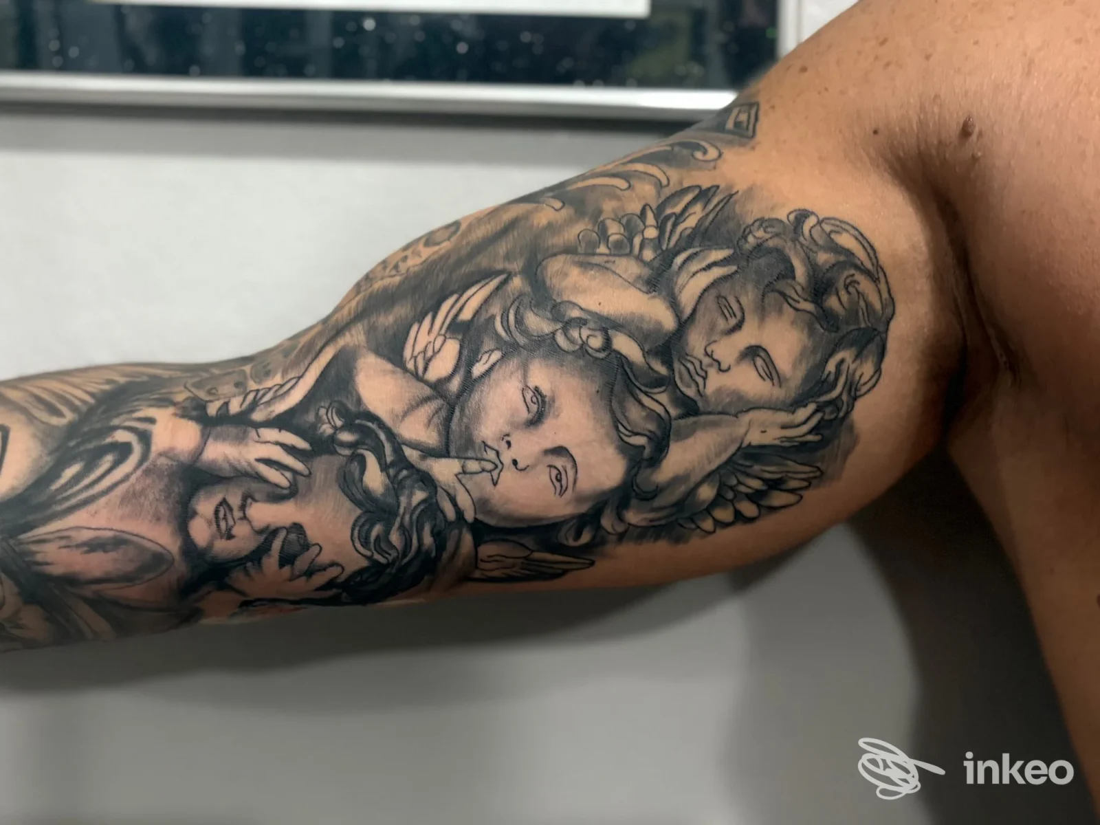 Tatuaggio black & grey di cherubini sul braccio, foto inviata da The Saints Tattoo studio, Caselle Torinese.