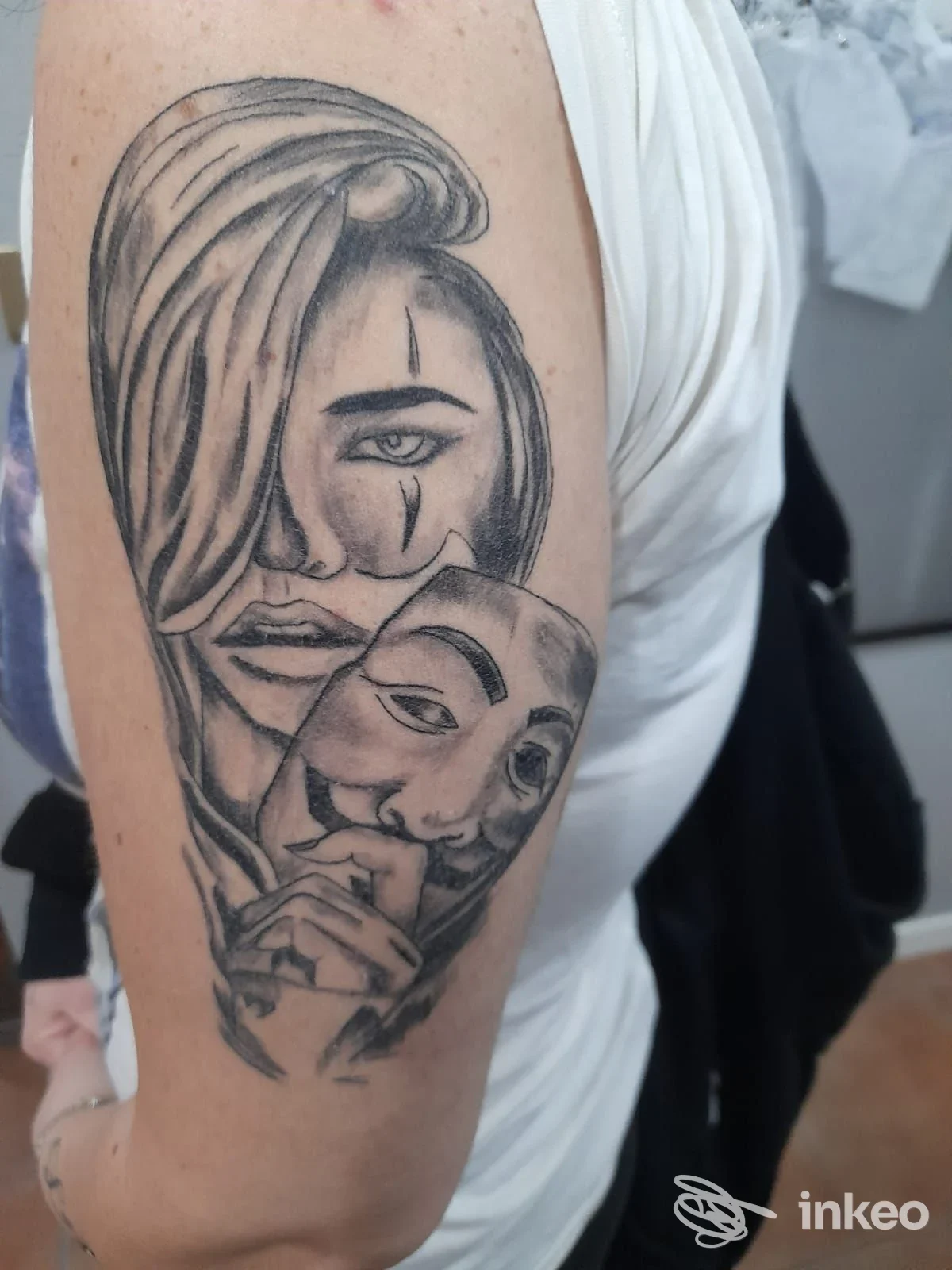 Tatuaggio in bianco e nero su braccio superiore presso The Saints Tattoo studio, Caselle Torinese, ritratto femminile con maschera.