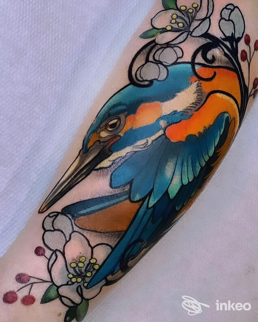 Tatuaggio a colori di un martin pescatore con fiori sull'avambraccio, White Raven Tattoo & Art gallery, Torino.