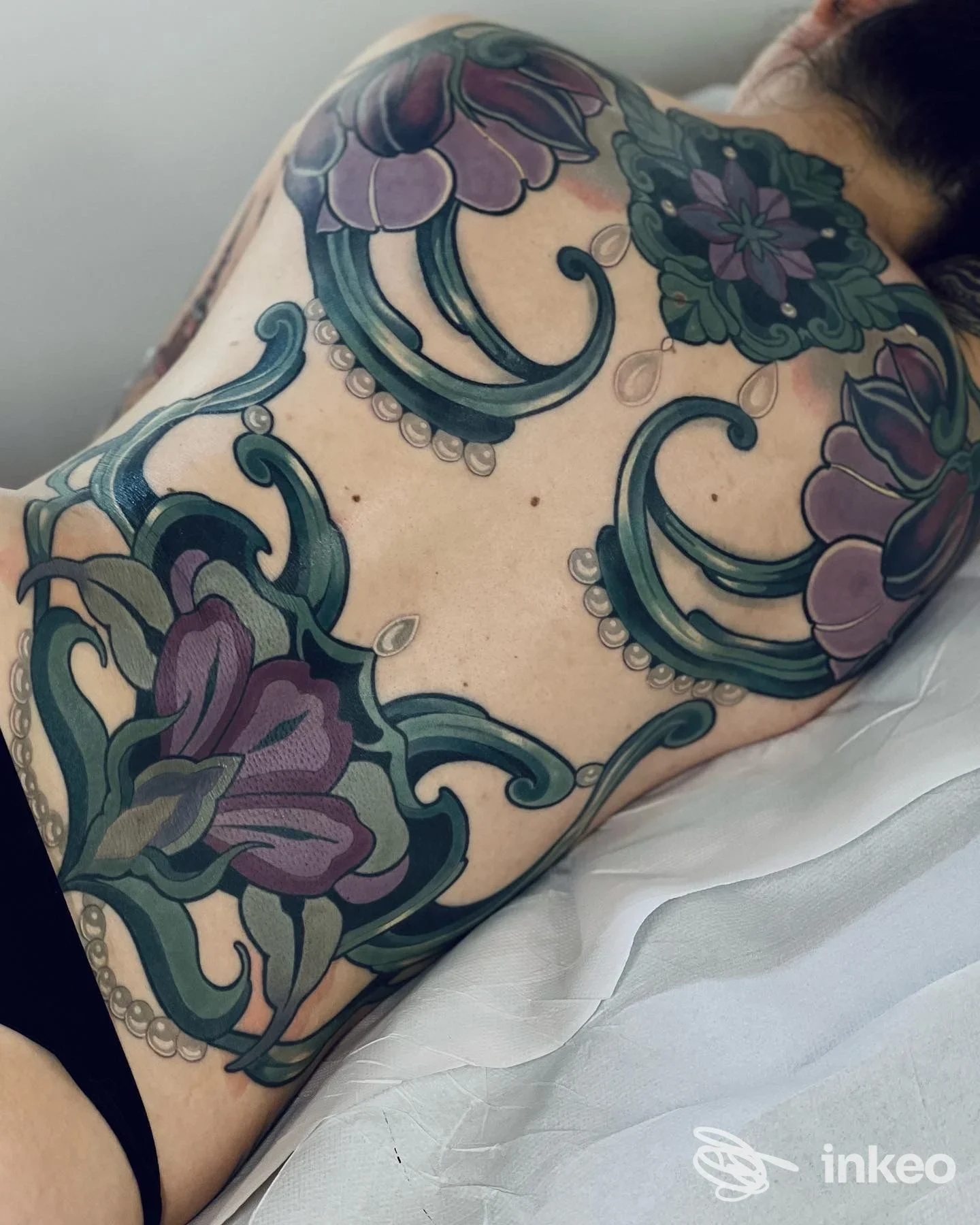 Ampio tatuaggio floreale ornamentale sulla schiena, foto condivisa da White Raven Tattoo & Art gallery, Torino.