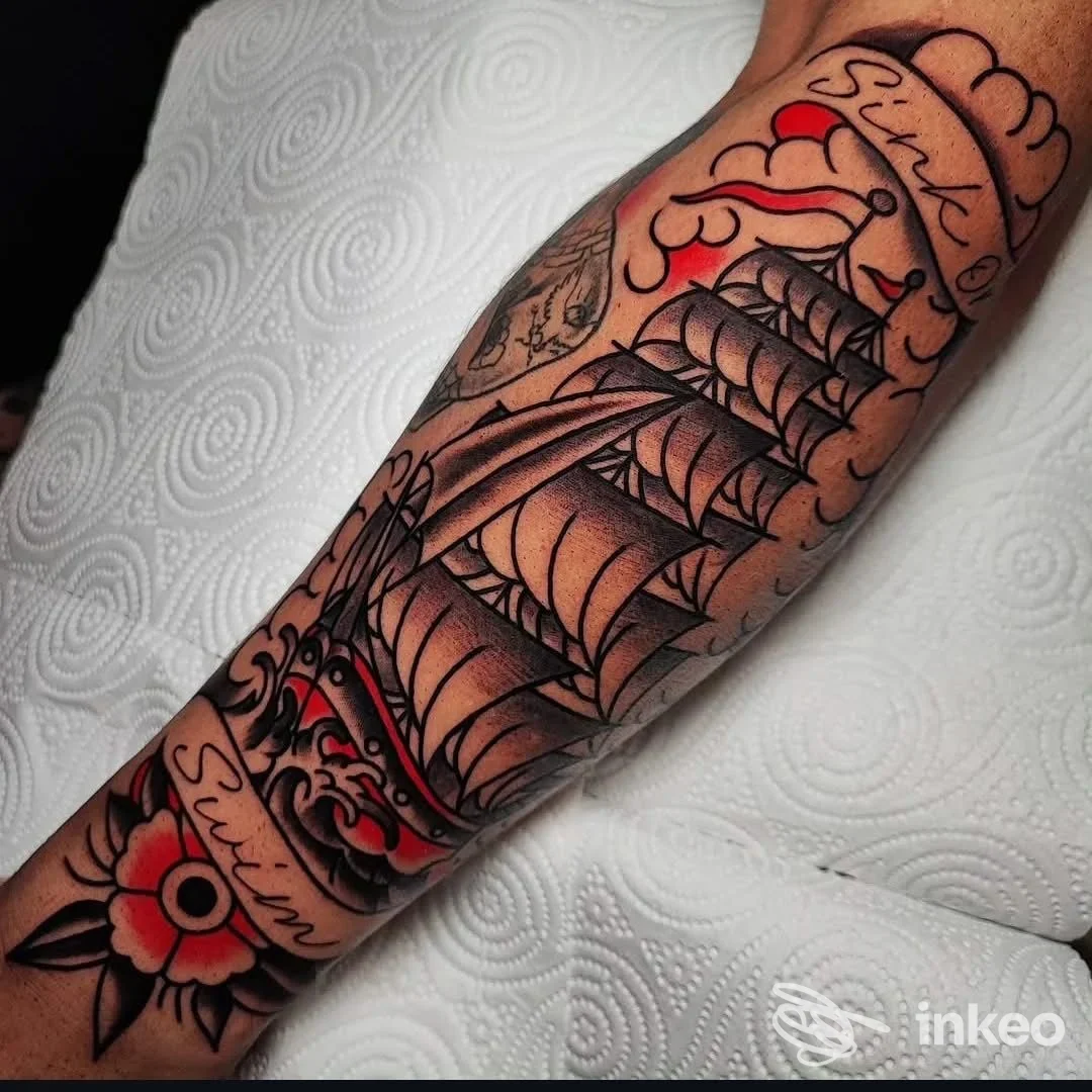 Avambraccio tatuato con grande nave a vele in nero e rosso, foto realizzata per ZETA Tattoo Shop a Novara.