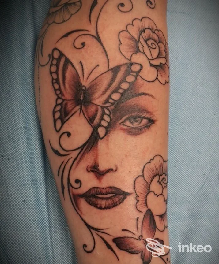 Tatuaggio su avambraccio: volto femminile con farfalle e fiori, Art Tattoo di Roberto Mossino, Chiusa di San Michele.