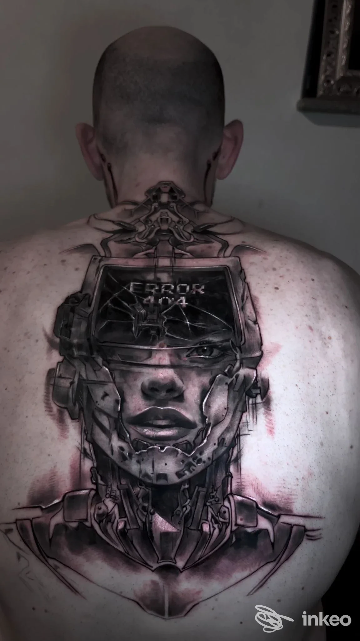 Grande tatuaggio biomeccanico su nuca e schiena, realizzato da 81's Black Sheep Tattoo Studio a Vinovo, con tonalità scure e accenti rossastri.