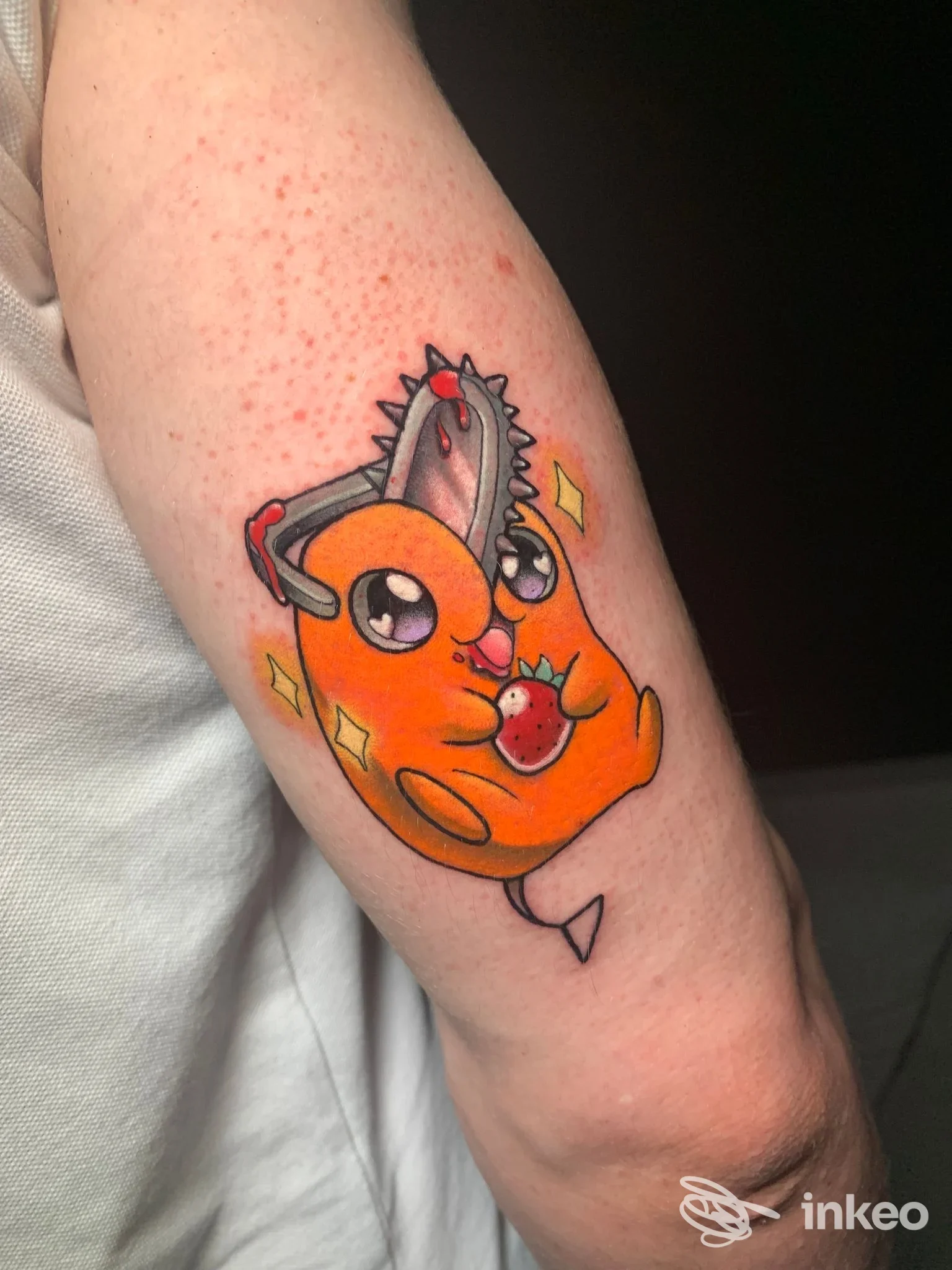 Tatuaggio su avambraccio con personaggio arancione in stile cartoon, realizzato da Apomorphy Tattoo Gallery, Chieri.